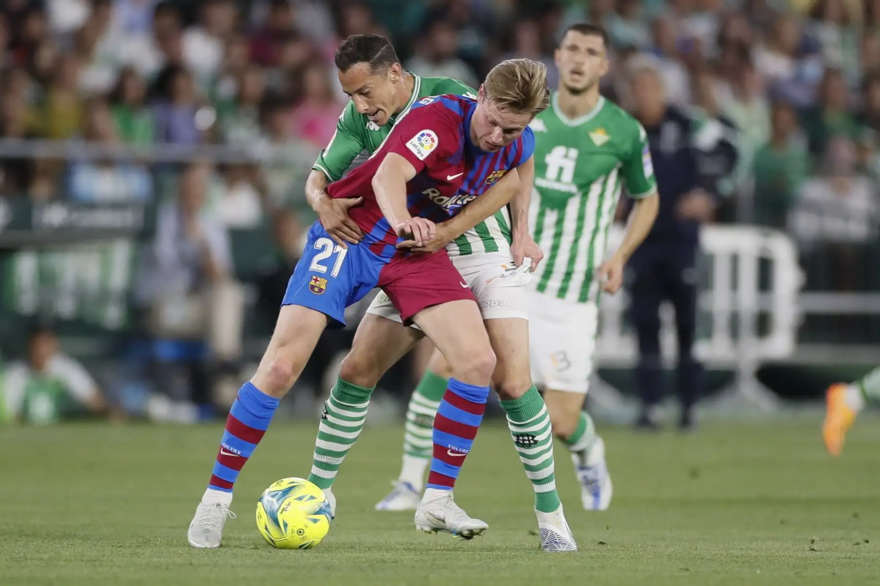 El centrocampista mexicano del Real Betis, José Andrés Guardado, lucha con el neerlandés Frenkie De Jong, del FC Barcelona, durante el partido de la jornada 35 de LaLiga Santander, en el estadio Benito Villamarín, Sevilla. Foto: EFE