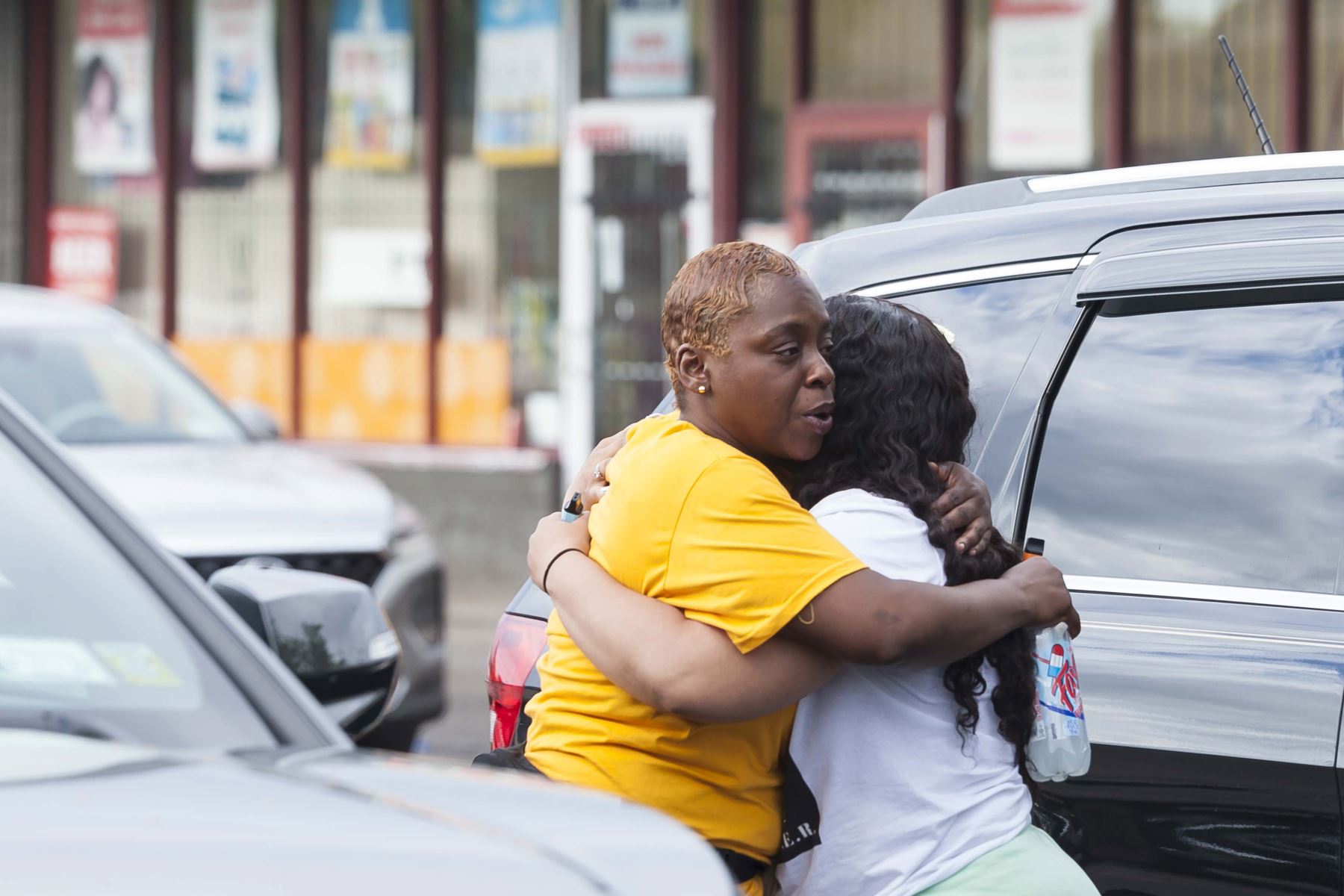 Dos personas se abrazan cerca de la escena de un tiroteo masivo en la tienda de comestibles Tops Friendly Market, en Buffalo, Nueva York. Foto: EFE