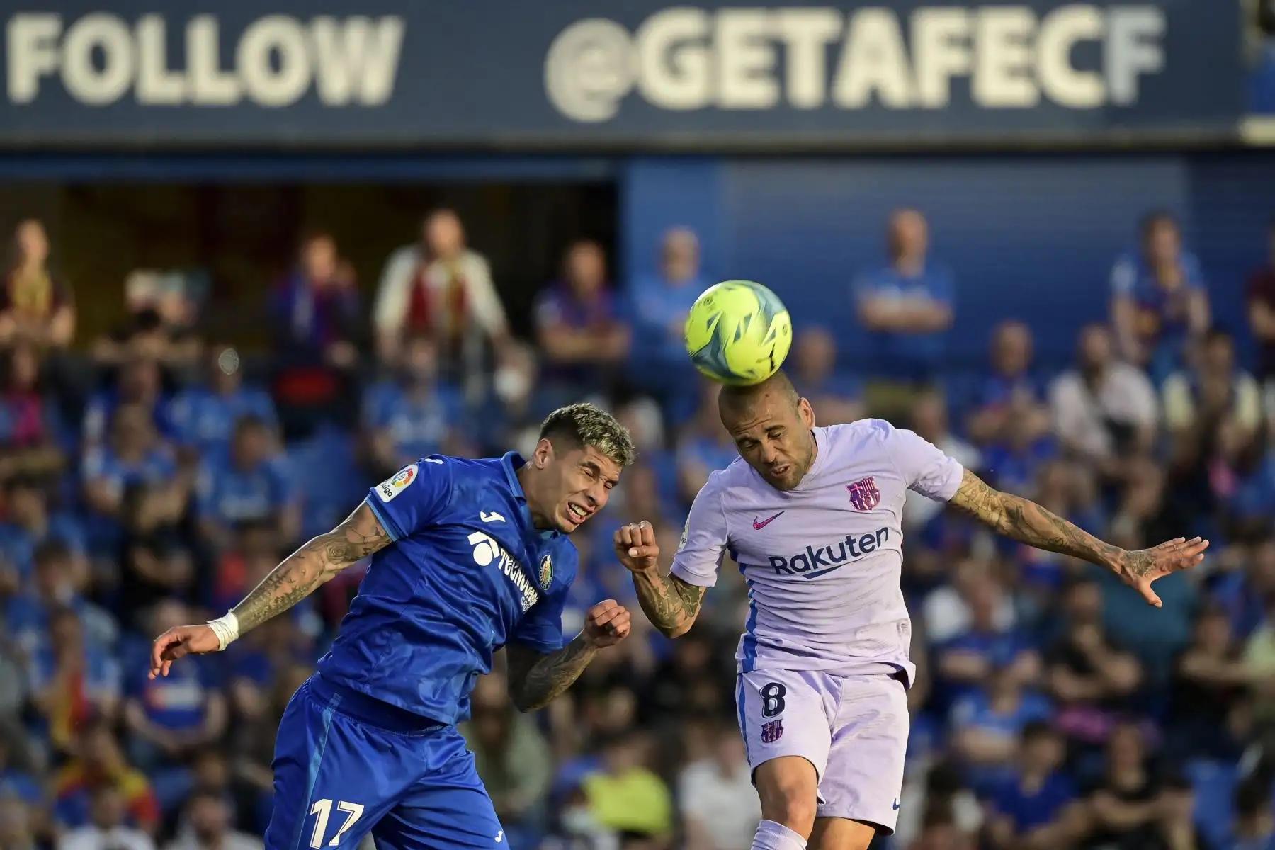 El defensor uruguayo de Getafe Mathias Olivera (L) y el defensor brasileño de Barcelona Dani Alves saltan por el balón durante el partido de fútbol de la liga española entre el Getafe CF y el FC Barcelona en el estadio Col. Alfonso Pérez de Getafe. Foto: AFP