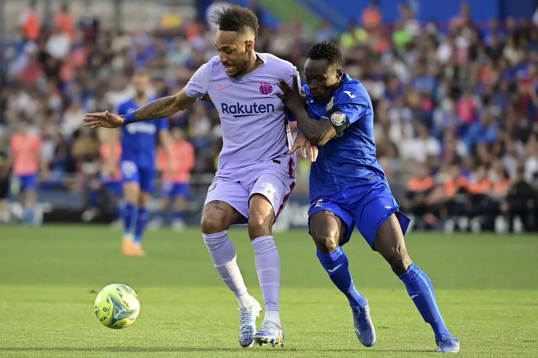 El centrocampista gabonés de Barcelona Pierre-Emerick Aubameyang (L) lucha por el balón con el defensor togolés de Getafe Djene Dakonam durante el partido de fútbol de la liga española entre el Getafe CF y el FC Barcelona en el estadio Col. Alfonso Pérez de Getafe. Foto: AFP