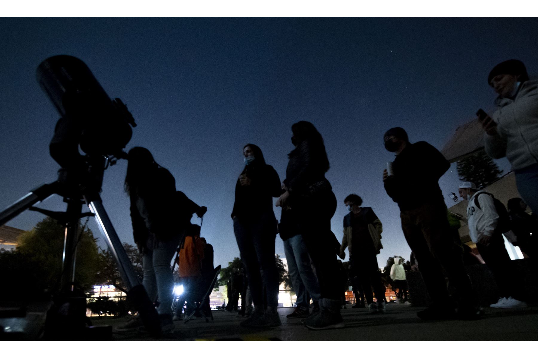 La gente mira la luna antes de un eclipse lunar total rojo sangre en Santiago, Chile. Foto: AFP