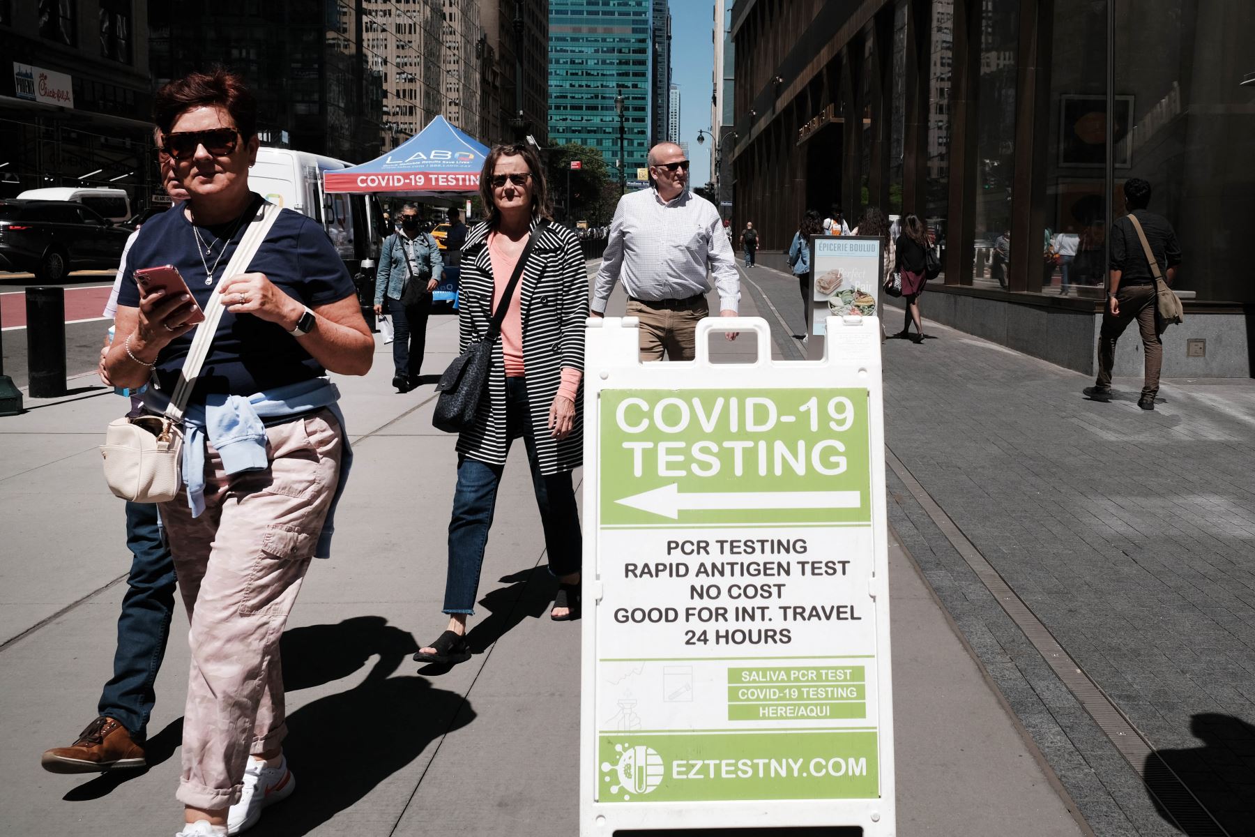 La gente pasa por un sitio de prueba de Covid en la ciudad de Nueva York. El comisionado de salud de Nueva York, el Dr. Ashwin Vasan, pasó de un nivel de alerta de COVID-19 "medio" a un nivel de alerta "alto" en los cinco condados luego de un aumento en los casos. Foto: AFP