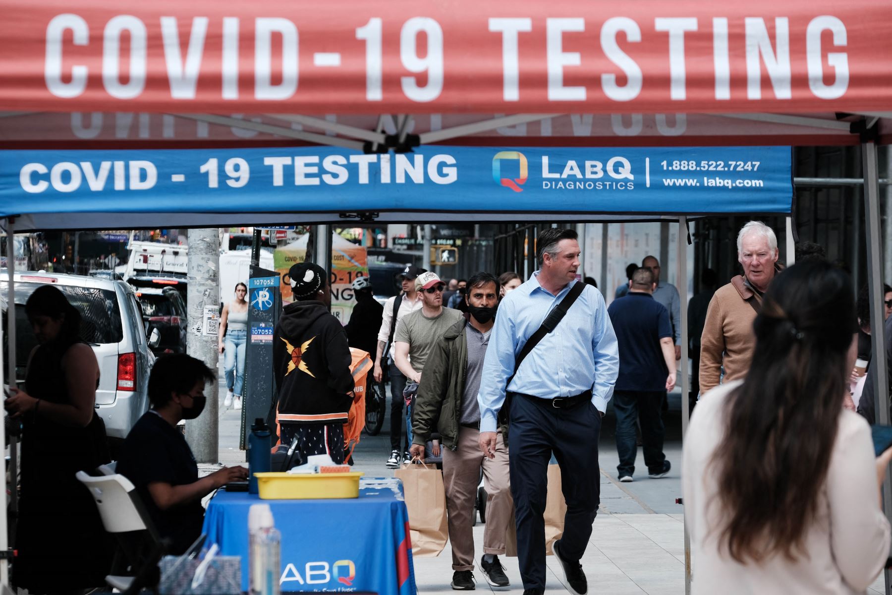 La gente pasa por un sitio de prueba de Covid en la ciudad de Nueva York. El comisionado de salud de Nueva York, el Dr. Ashwin Vasan, pasó de un nivel de alerta de COVID-19 "medio" a un nivel de alerta "alto" en los cinco condados luego de un aumento en los casos. Foto: AFP