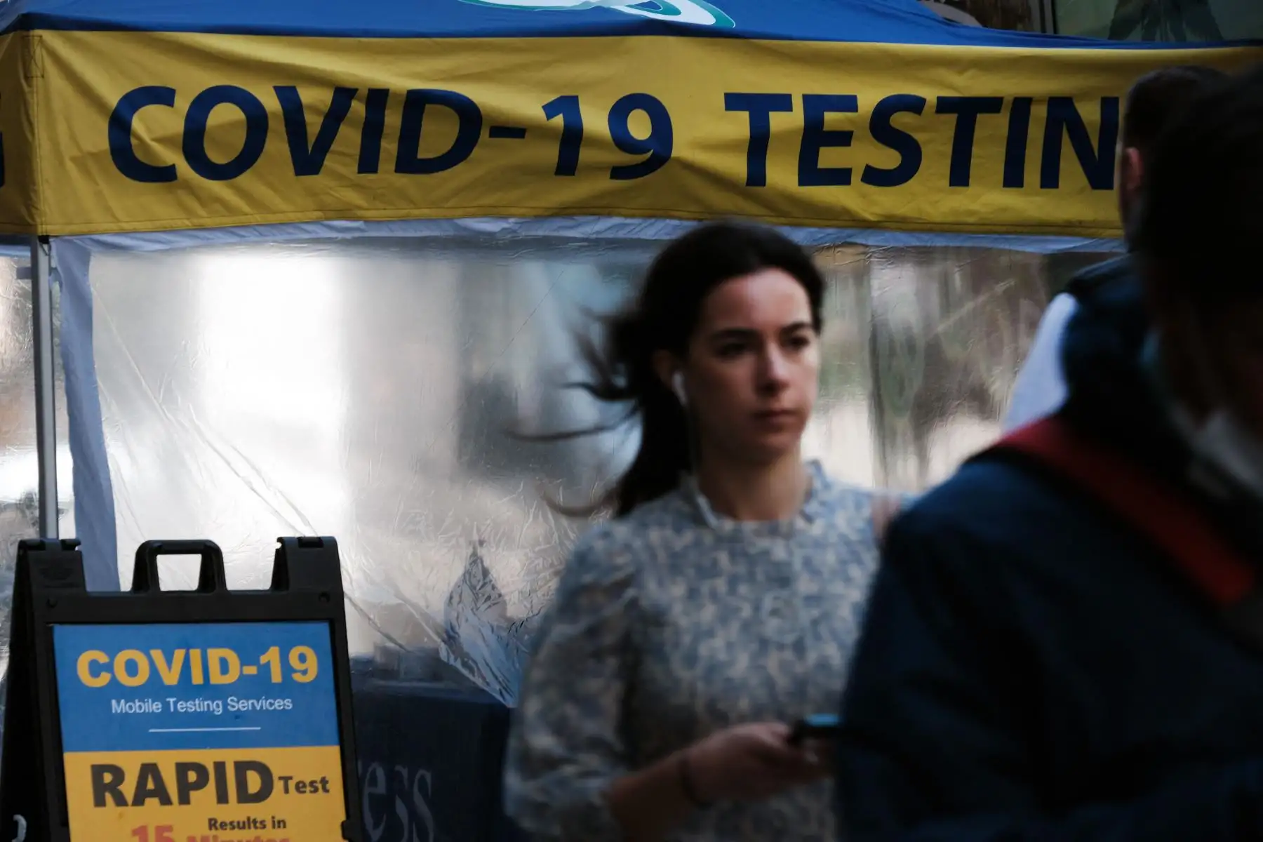 La gente pasa por un sitio de prueba de Covid en la ciudad de Nueva York. El comisionado de salud de Nueva York, el Dr. Ashwin Vasan, pasó de un nivel de alerta de COVID-19 "medio" a un nivel de alerta "alto" en los cinco condados luego de un aumento en los casos. Foto: AFP