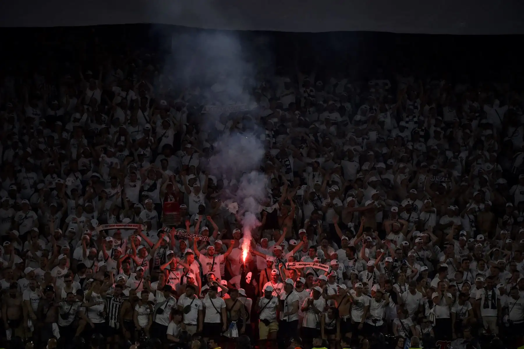 Un hincha del Eintracht Frankfurt sostiene una bengala mientras otros agradecen a su equipo que ganó la final de la UEFA Europa League. Foto: AFP