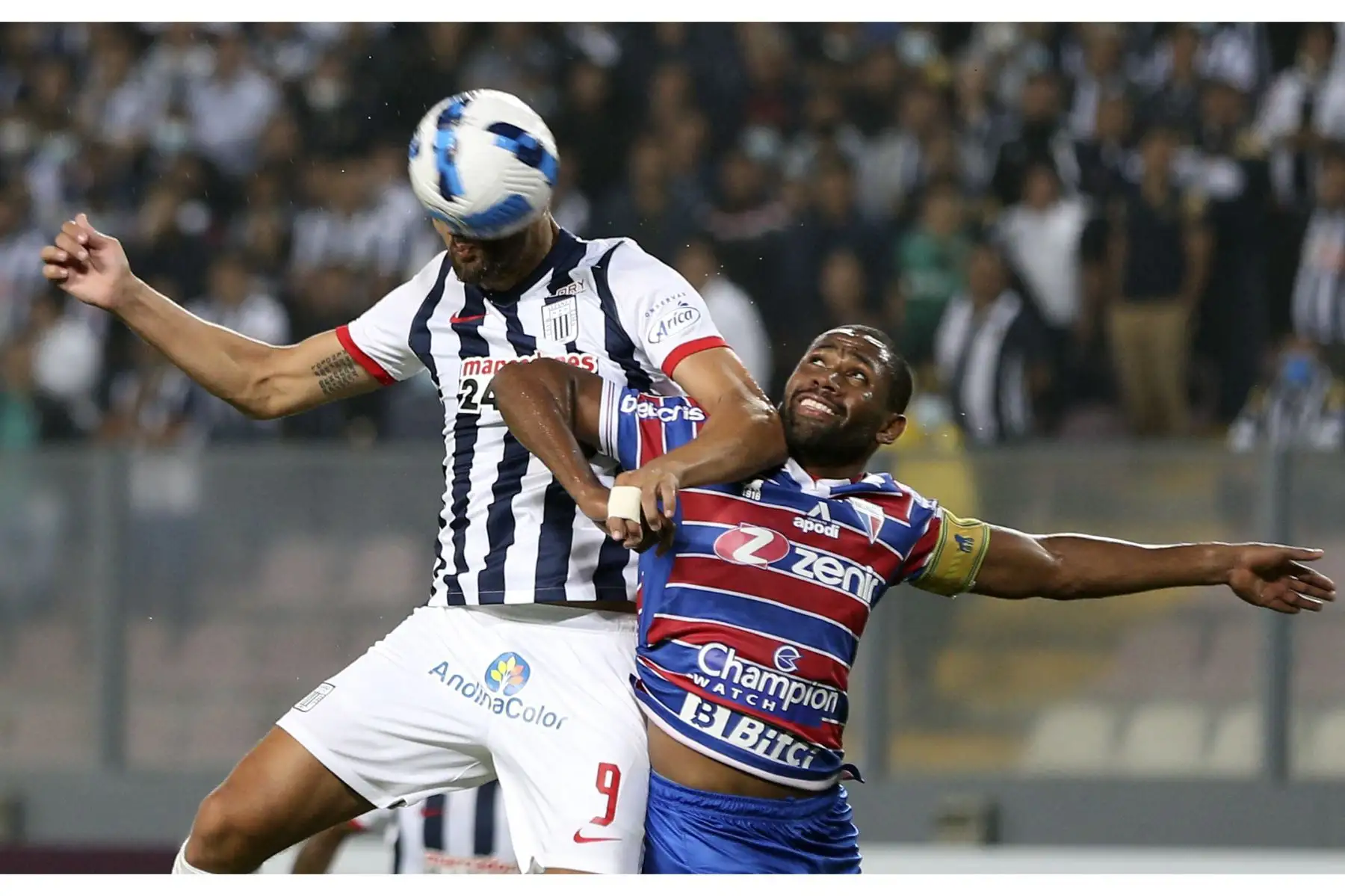 El argentino Hernán Barcos de Alianza Lima y su rival de Fortaleza compiten por el balón durante partido de la fase de grupos de la Copa Libertadores. Foto: AFP