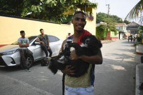 Ya no solo es un perro, también "es un migrante", dice Gilberto sin dejar de sonreír. Foto: AFP