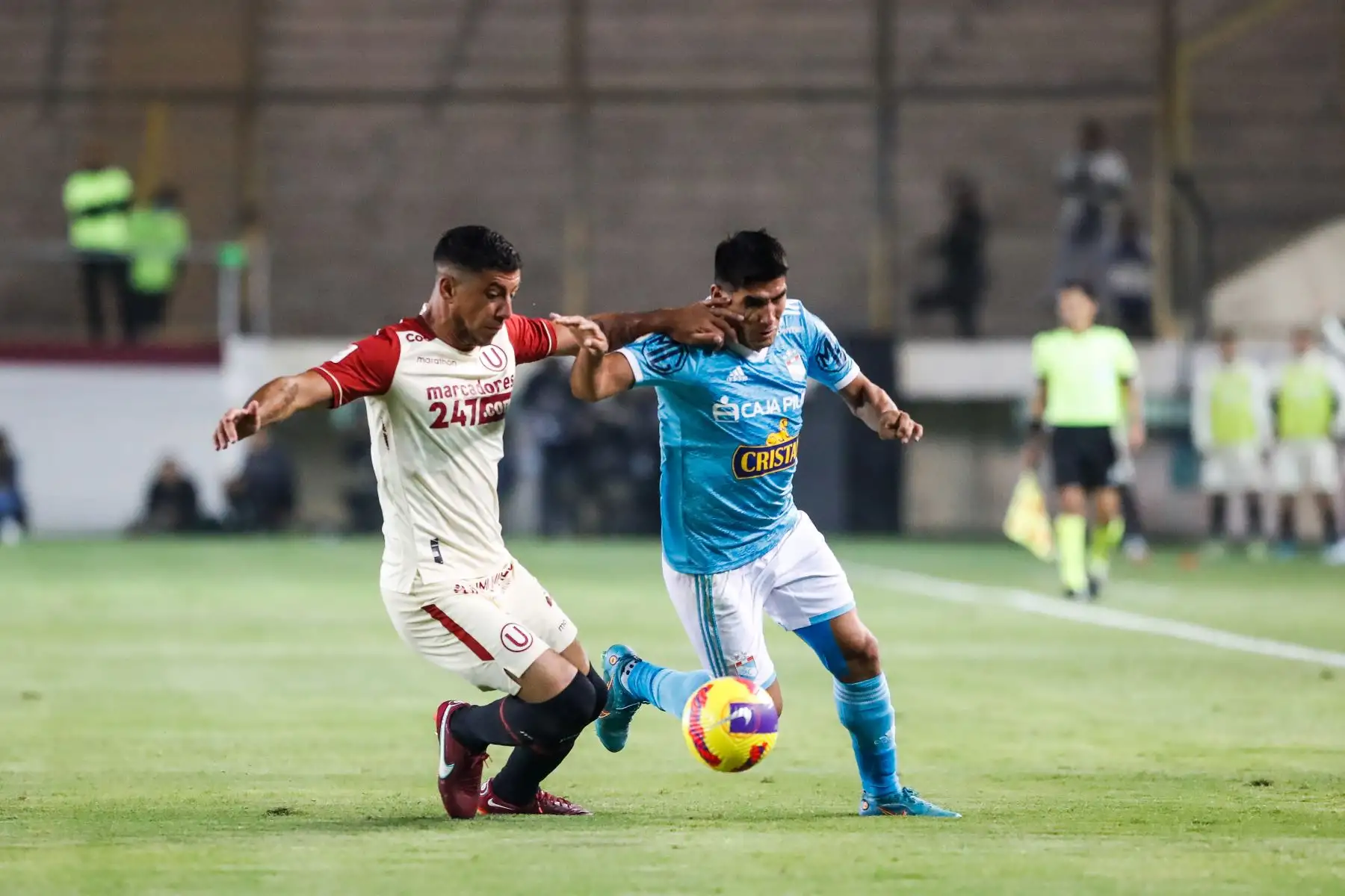 Irven Ávila de Sporting Cristal disputa el balón con su rival de Universitario durante partido por la jornada 15 de la Liga 1, en el Estadio Monumental. Foto: ANDINA/Renato Pajuelo
