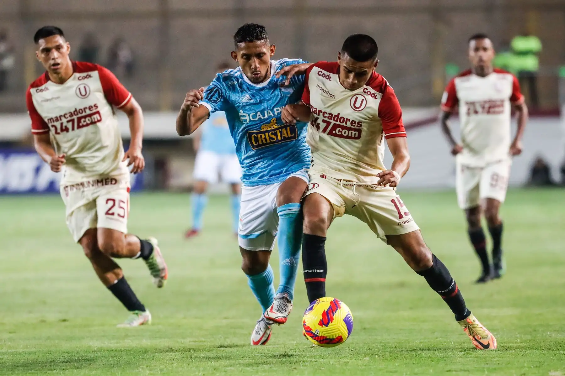 Christofer Gonzales de Sporting Cristal disputa el balón con su rival de Universitario durante partido por la jornada 15 de la Liga 1, en el Estadio Monumental. Foto: ANDINA/Renato Pajuelo