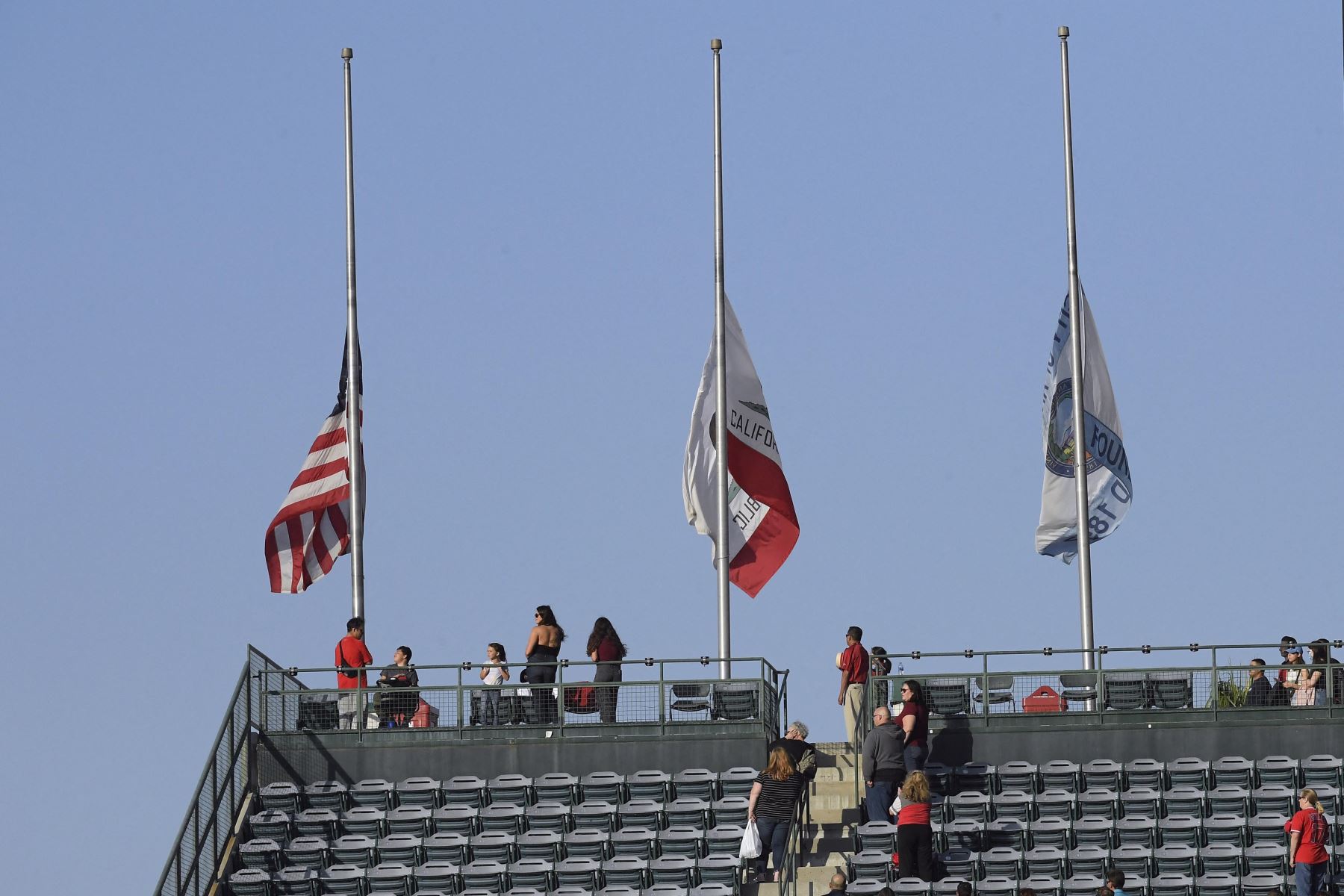La bandera estadounidense, la bandera de California y la bandera de la ciudad de Anaheim se bajan a media asta durante un momento de silencio por las víctimas del tiroteo masivo en la Escuela Primaria Robb en Uvalde, Texas. Foto: AFP