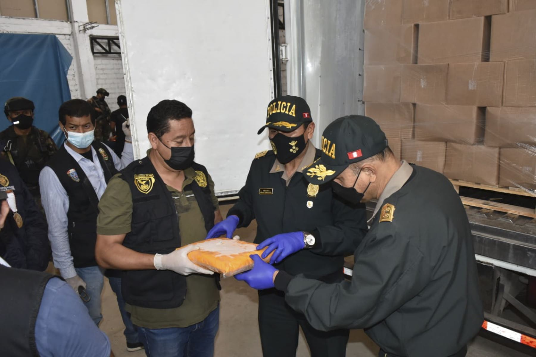 Los altos mandos de la Policía Nacional muestran uno de los paquetes que contiene la droga, una sustancia de color amarillo que simulaba ser pulpa de mango. Foto: ANDINA/PNP