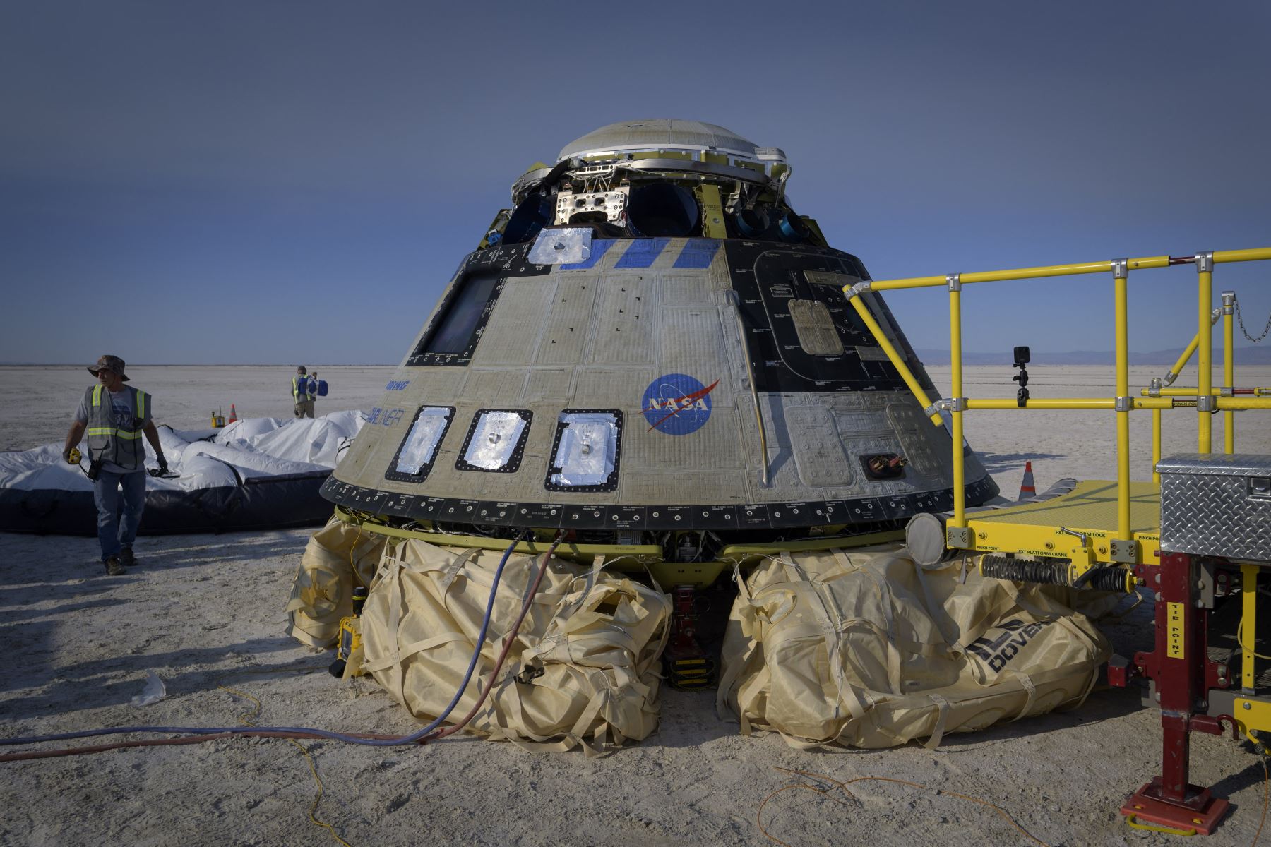 En esta imagen cortesía de la NASA, Boeing y los equipos de la NASA trabajan alrededor de la nave espacial CST-100 Starliner de Boeing después de que aterrizó en el puerto espacial de White Sands Missile Range, el 25 de mayo de 2022, en Nuevo México.
Foto: NASA/AFP