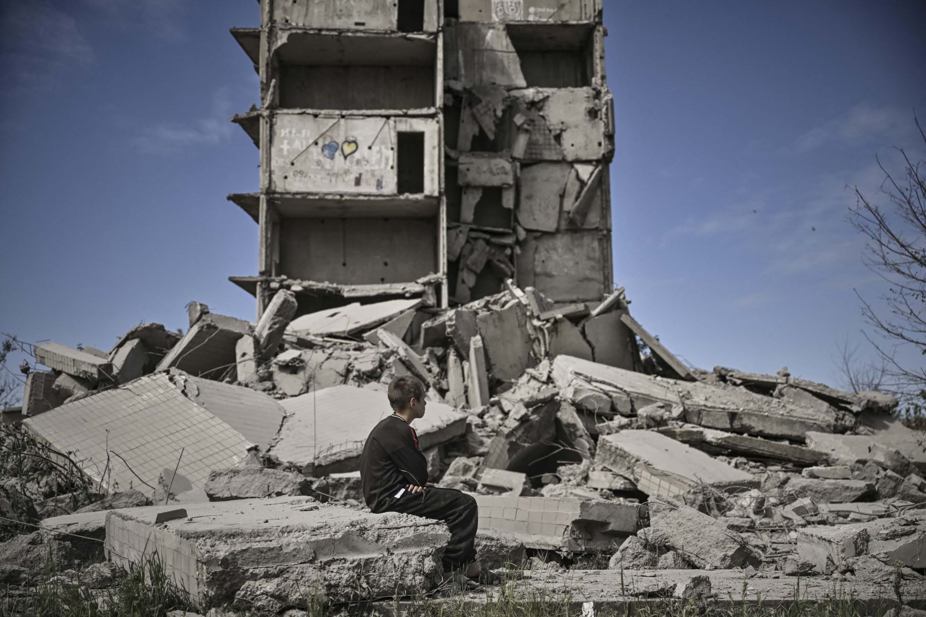 Un niño se sienta frente a un edificio destruido en Kramatorsk, en la región oriental de Ucrania de Donbas. Foto: AFP