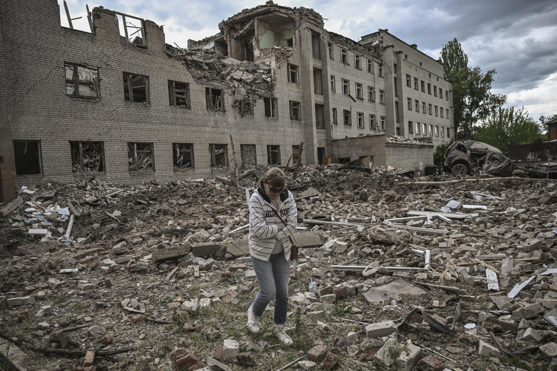 Una mujer pasa frente a un edificio administrativo destruido en la ciudad de Bakhmut, en la región oriental de Ucrania de Donbas. Foto: AFP