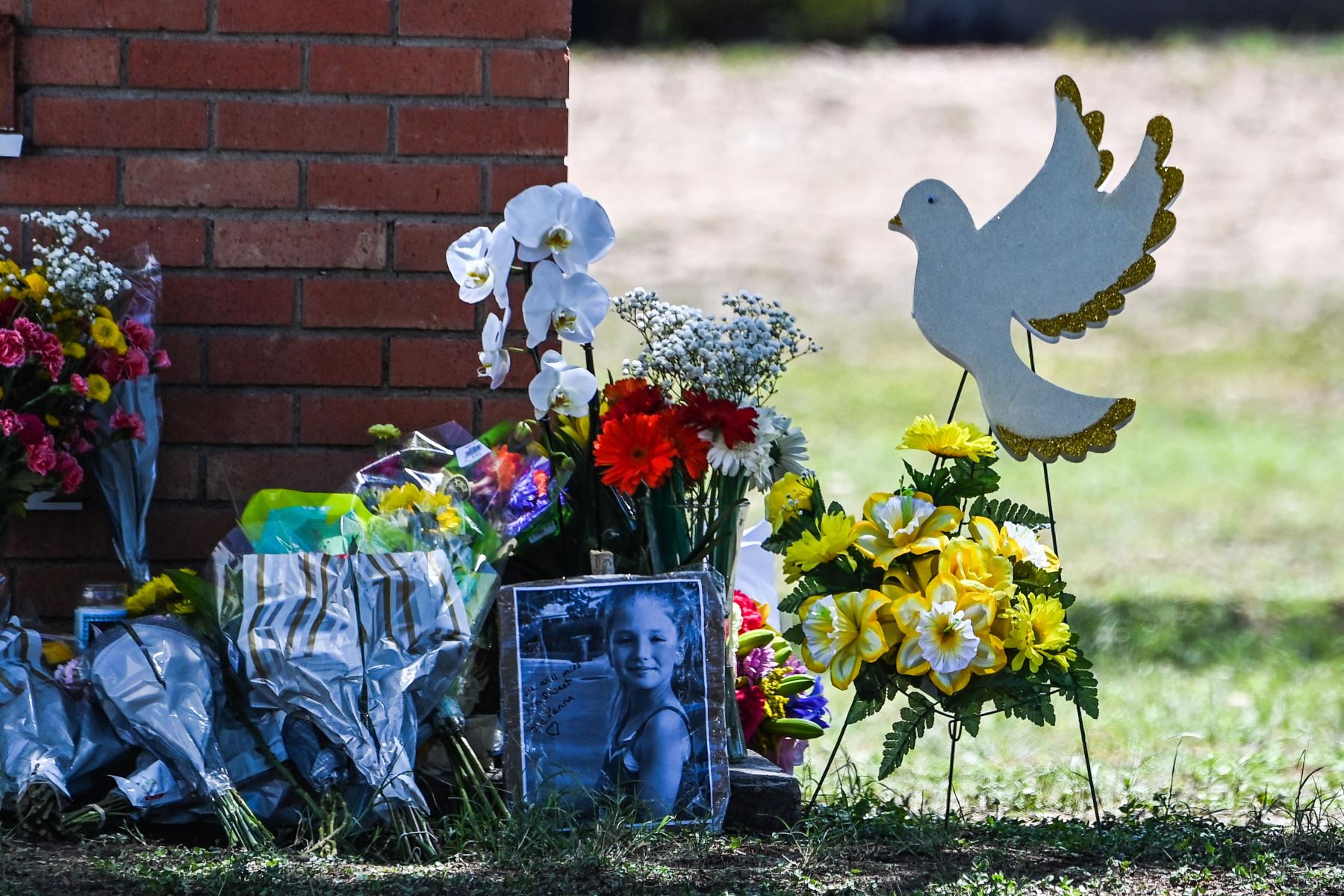 La foto de una niña víctima del tiroteo, se ve junto a las flores colocadas en un monumento improvisado frente a la Escuela Primaria Robb en Uvalde, Texas. Foto: AFP