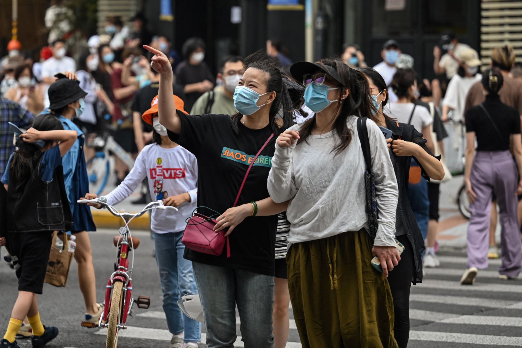 Las personas con un pase de dos o tres horas de sus complejos residenciales caminan por una calle durante un bloqueo de coronavirus Covid-19 en el distrito de Jing