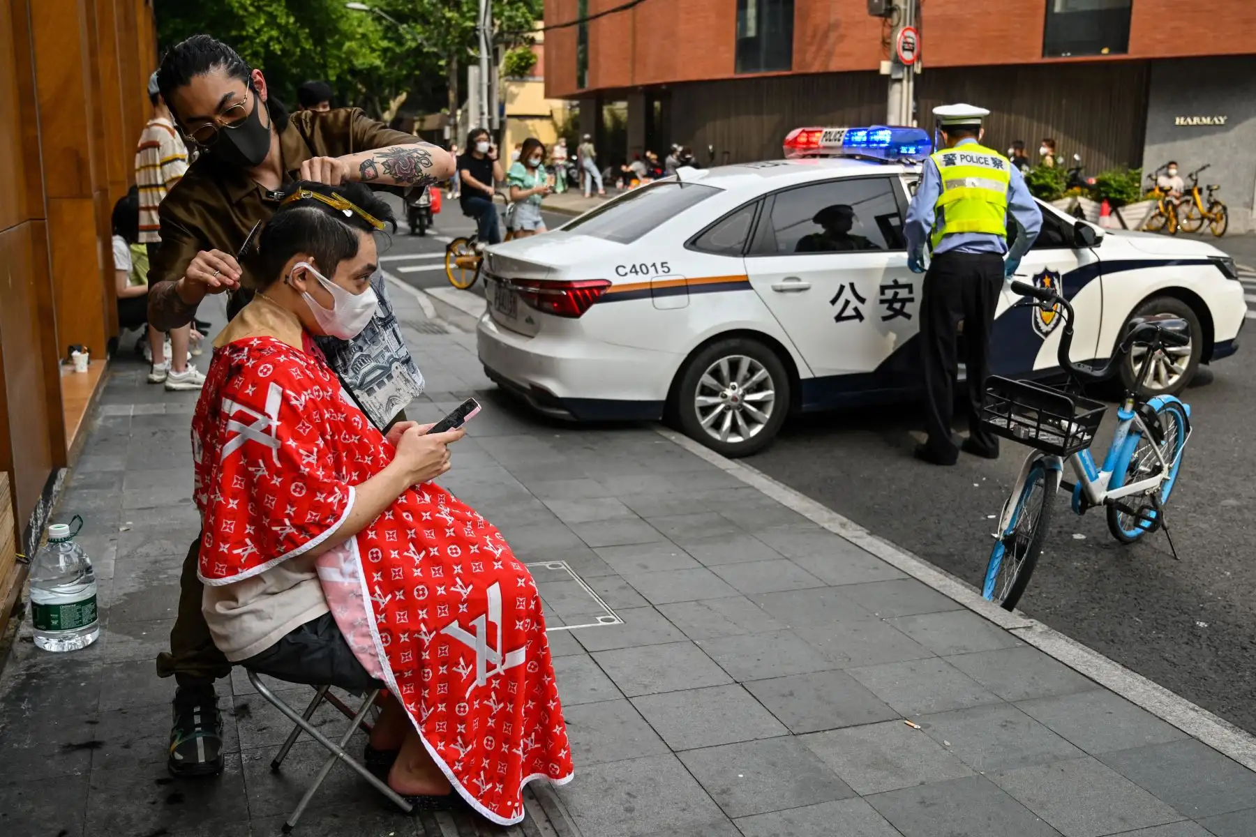 Un hombre se corta el pelo en una calle durante un confinamiento por el coronavirus Covid-19 en Shanghái el 27 de mayo de 2022. Foto: AFP