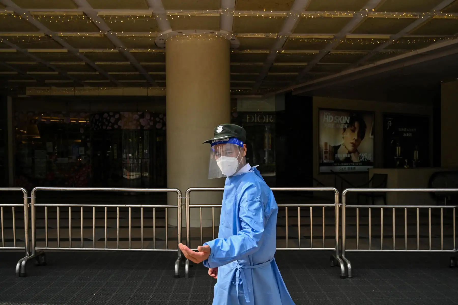 Un guardia de seguridad se encuentra frente a la entrada de un centro comercial cerrado durante un bloqueo de coronavirus Covid-19 en el distrito de Jing