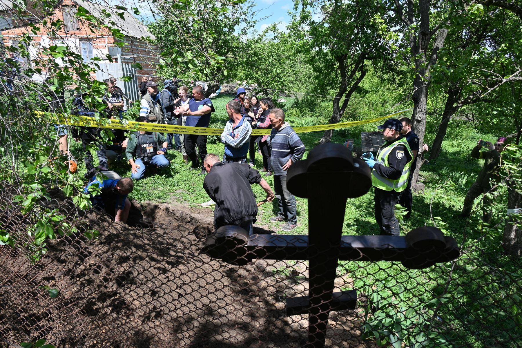 Expertos forenses de la policía ucraniana, asistidos por habitantes, exhuman el cuerpo de un residente de 32 años del pueblo de Koropy, cerca de Kharkiv en Ucrania.  Foto: AFP