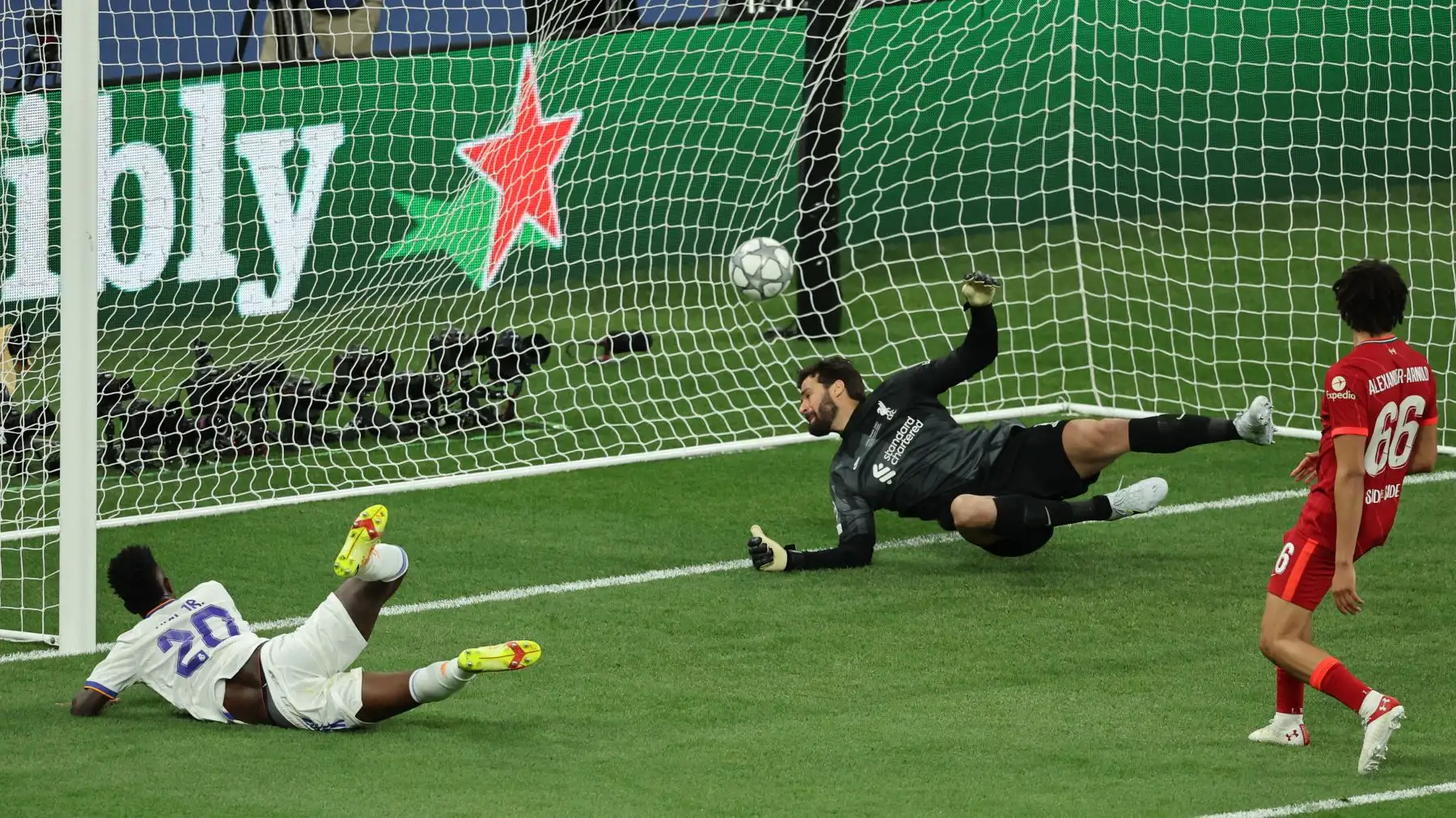El delantero brasileño del Real Madrid, Vinicius Junior (izq.), anota el gol de apertura ante el portero brasileño del Liverpool, Alisson Becker, durante el partido final de la Liga de Campeones de la UEFA entre el Liverpool y el Real Madrid. Foto: AFP