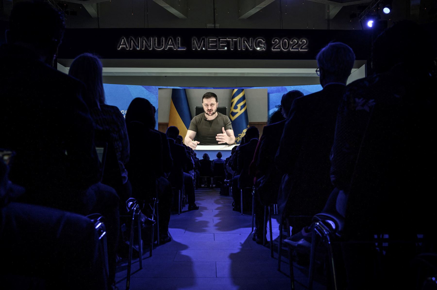 El presidente de Ucrania, Volodímir Zelenski, aparece en una pantalla gigante durante su discurso por videoconferencia como parte de la reunión anual del Foro Económico Mundial (FEM), en Davos, el 23 de mayo del 2022. Foto: AFP.