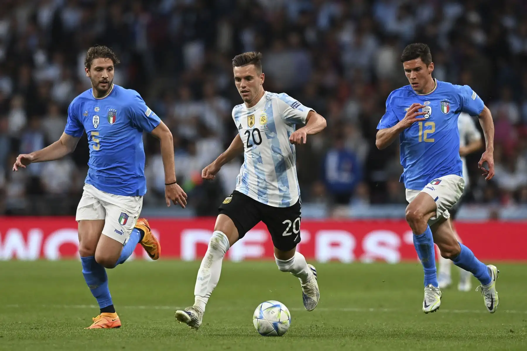 El mediocampista argentino Giovani Lo Celso (C) compite con el mediocampista italiano Manuel Locatelli (L) y el mediocampista italiano Matteo Pessina (D) durante el partido amistoso de fútbol internacional 