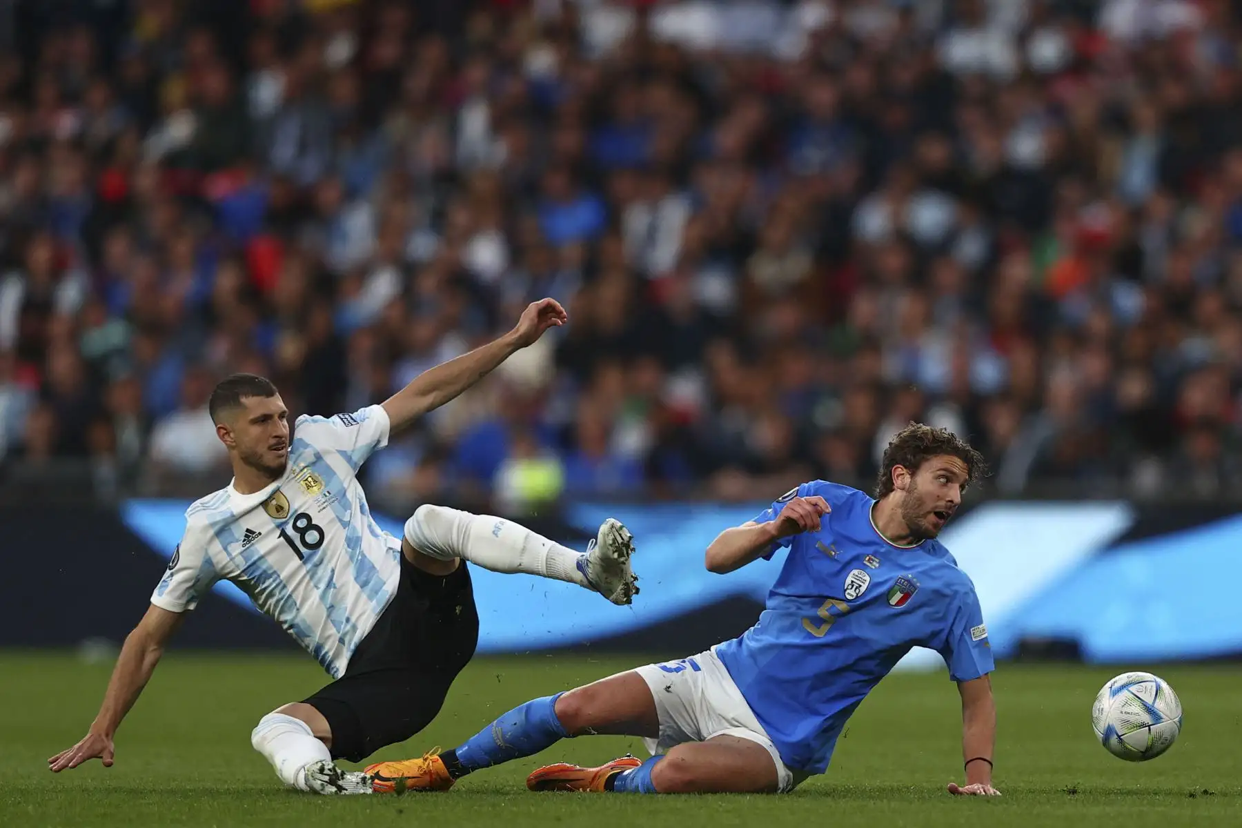 El mediocampista argentino Guido Rodríguez (I) compite con el mediocampista italiano Manuel Locatelli (D) durante el partido de fútbol amistoso internacional 