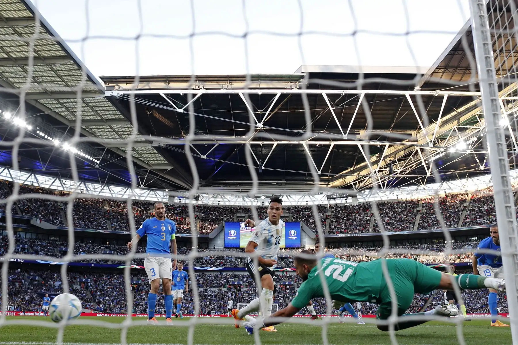 El delantero argentino Lautaro Martínez (C) dispara para marcar el gol de apertura del partido de fútbol amistoso internacional 