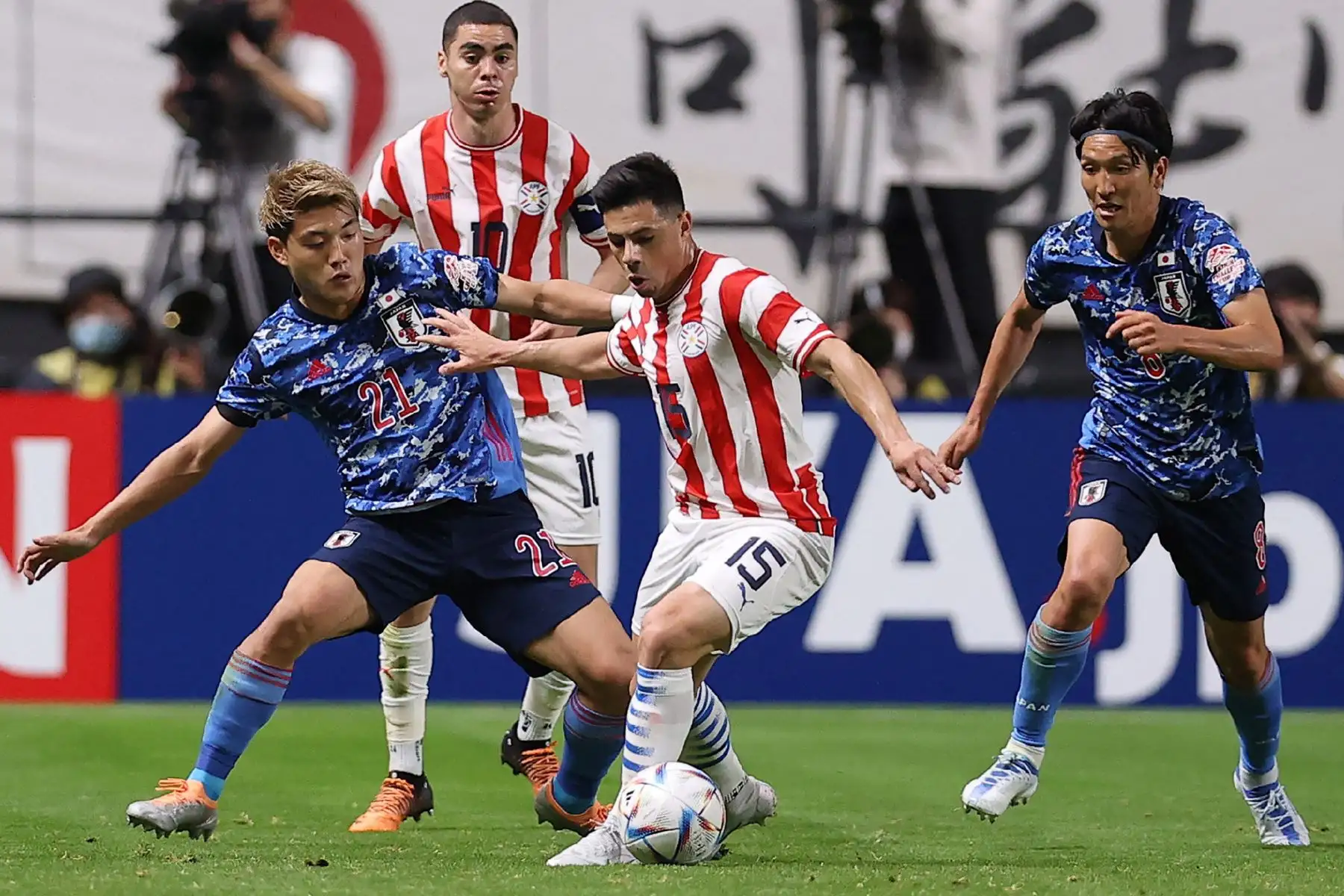 El defensor de Paraguay Blas Riveros compite por el balón con los mediocampistas de Japón Ritsu Doan  y Genki Haraguchi  durante el partido amistoso de fútbol internacional entre Japón y Paraguay en Sapporo Dome en Sapporo. Foto: AFP