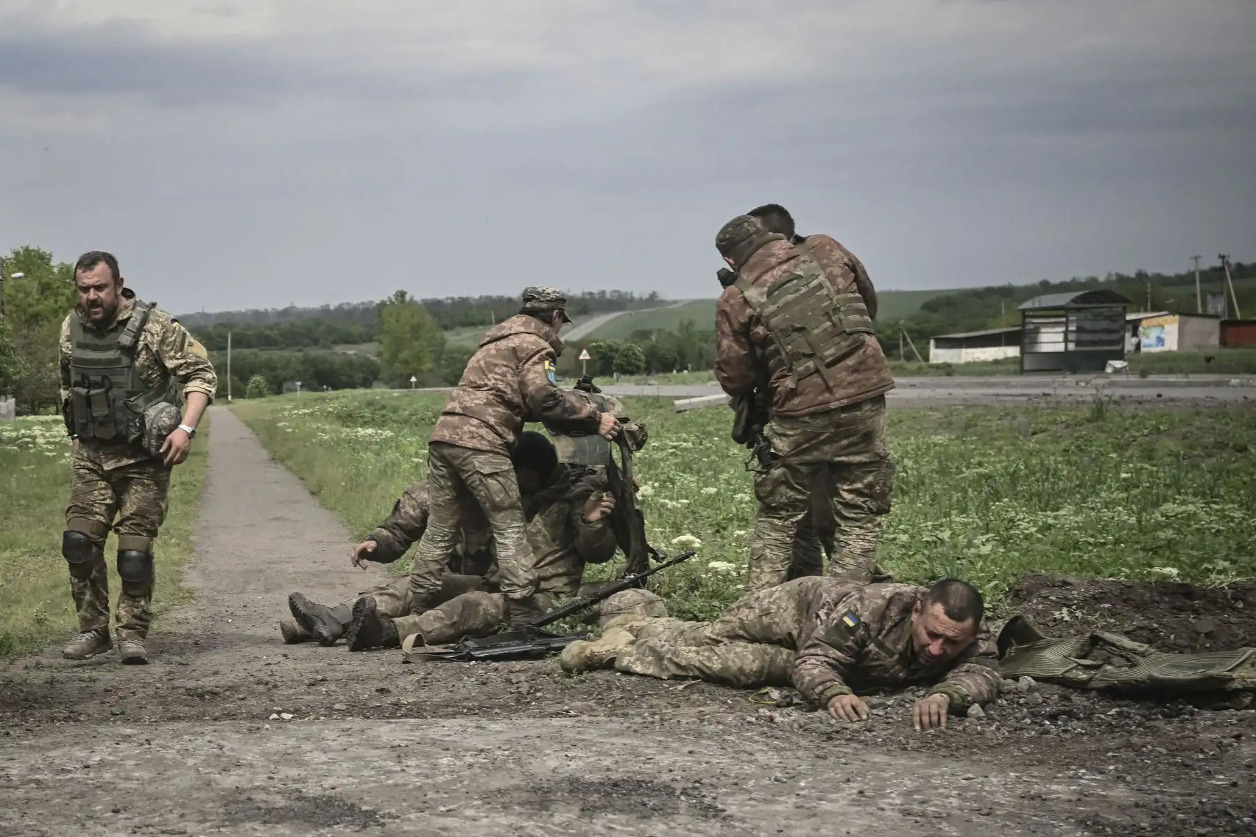 Los militares ucranianos ayudan a sus camaradas no lejos de la línea del frente en la región oriental de Ucrania de Donbas, el 21 de mayo de 2022. Foto: AFP