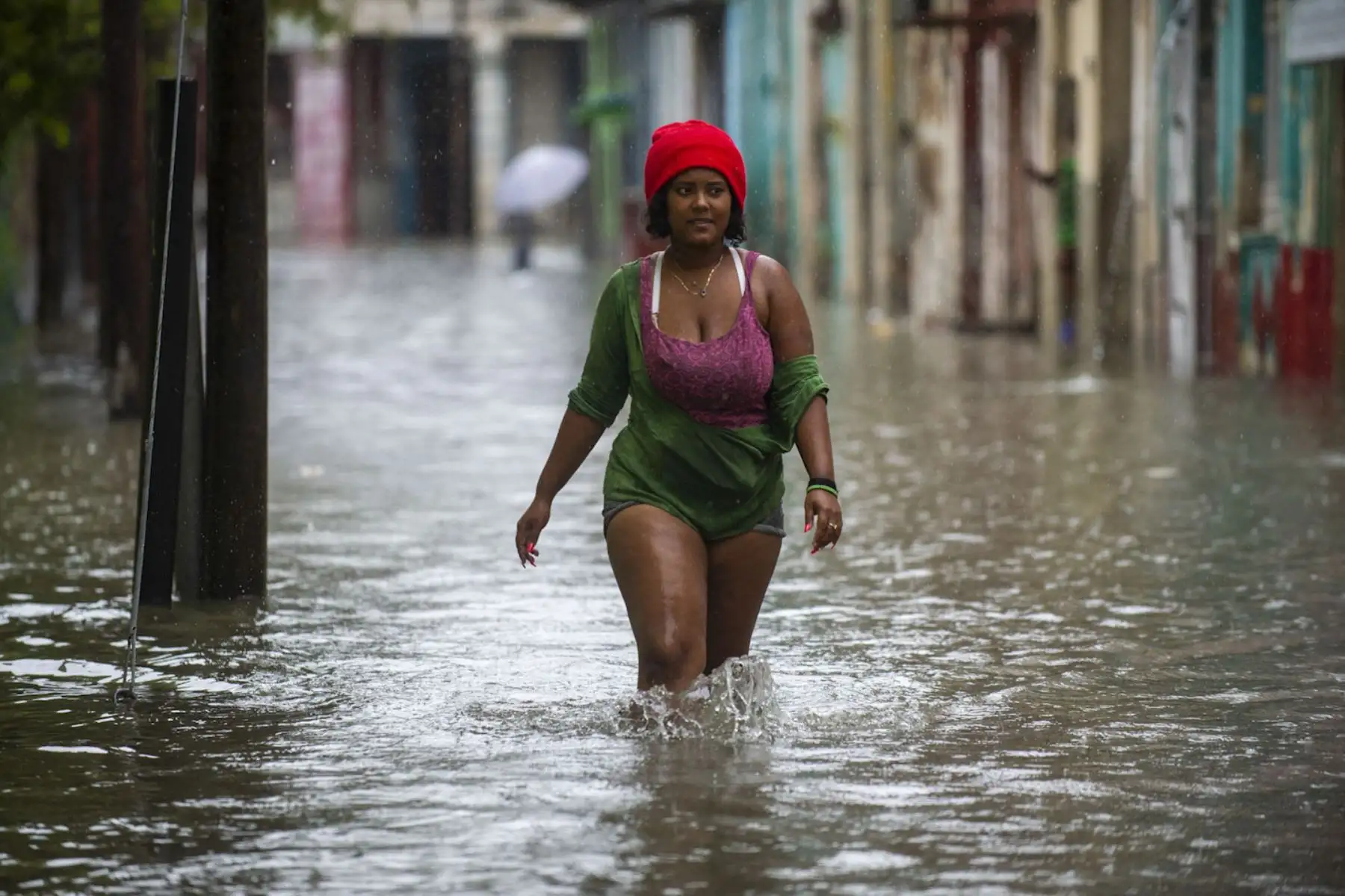 Una mujer camina por una calle inundada de La Habana. Los remanentes del huracán Agatha provocan este viernes intensas y persistentes lluvias en las provincias occidentales y centrales de Cuba. Foto: AFP