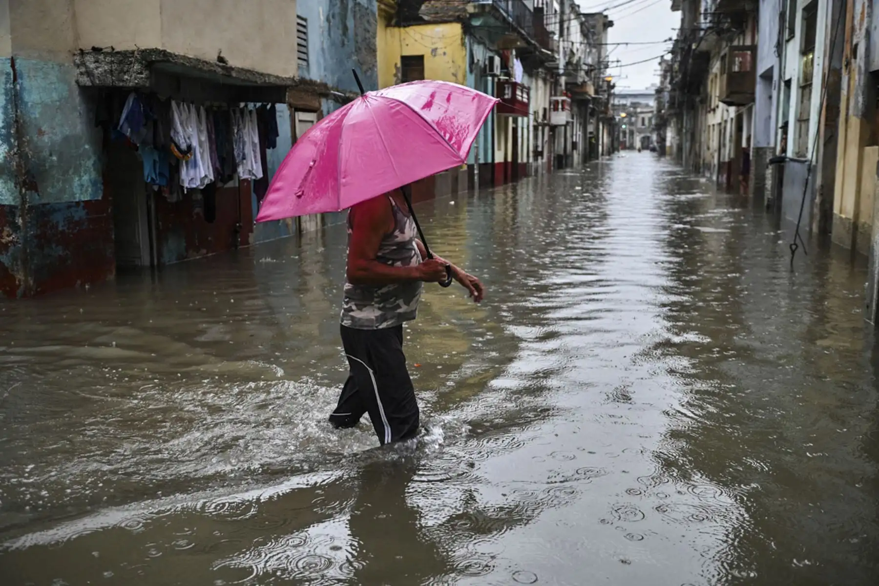 Un hombre con un paraguas camina una calle inundada de La Habana. - El remanente del huracán Agatha provoca este viernes intensas y persistentes lluvias en las provincias occidentales y centrales de Cuba. Foto: AFP