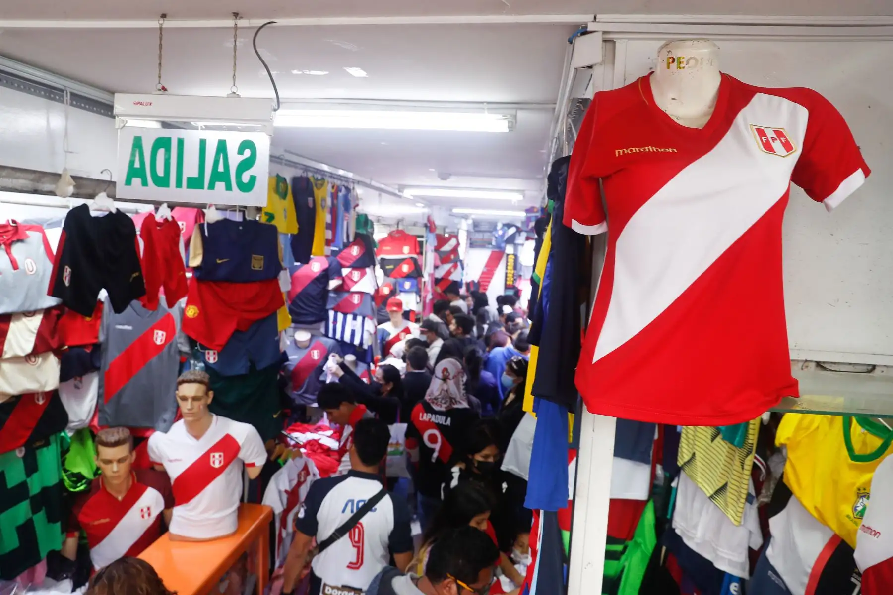 Gamarra se tiñe de rojo y blanco a dos días del repechaje frente a Australia rumbo a Catar 2022. Cientos de personas llegan al emporio comercial para adquirir las tradicionales camisetas, casacas y los famosos turbantes característico de nuestra selección. Foto: ANDINA/Renato Pajuelo