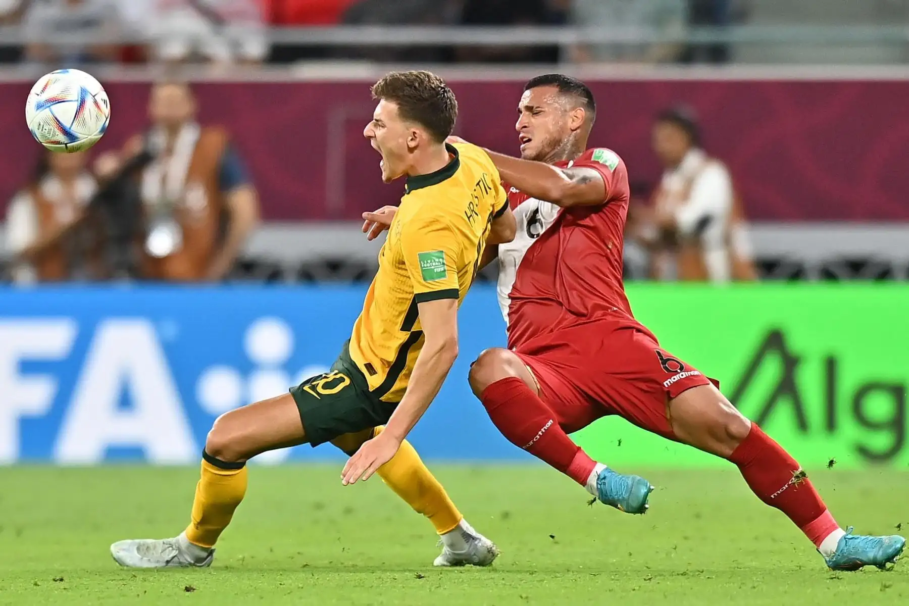 Ajdin Hrustic de Australia en acción contra Miguel Trauco  de Perú durante el partido de fútbol clasificatorio para el playoff Intercontinental de la Copa Mundial de la FIFA 2022 entre Australia y Perú en Al Rayyan, Qatar. Foto: EFE