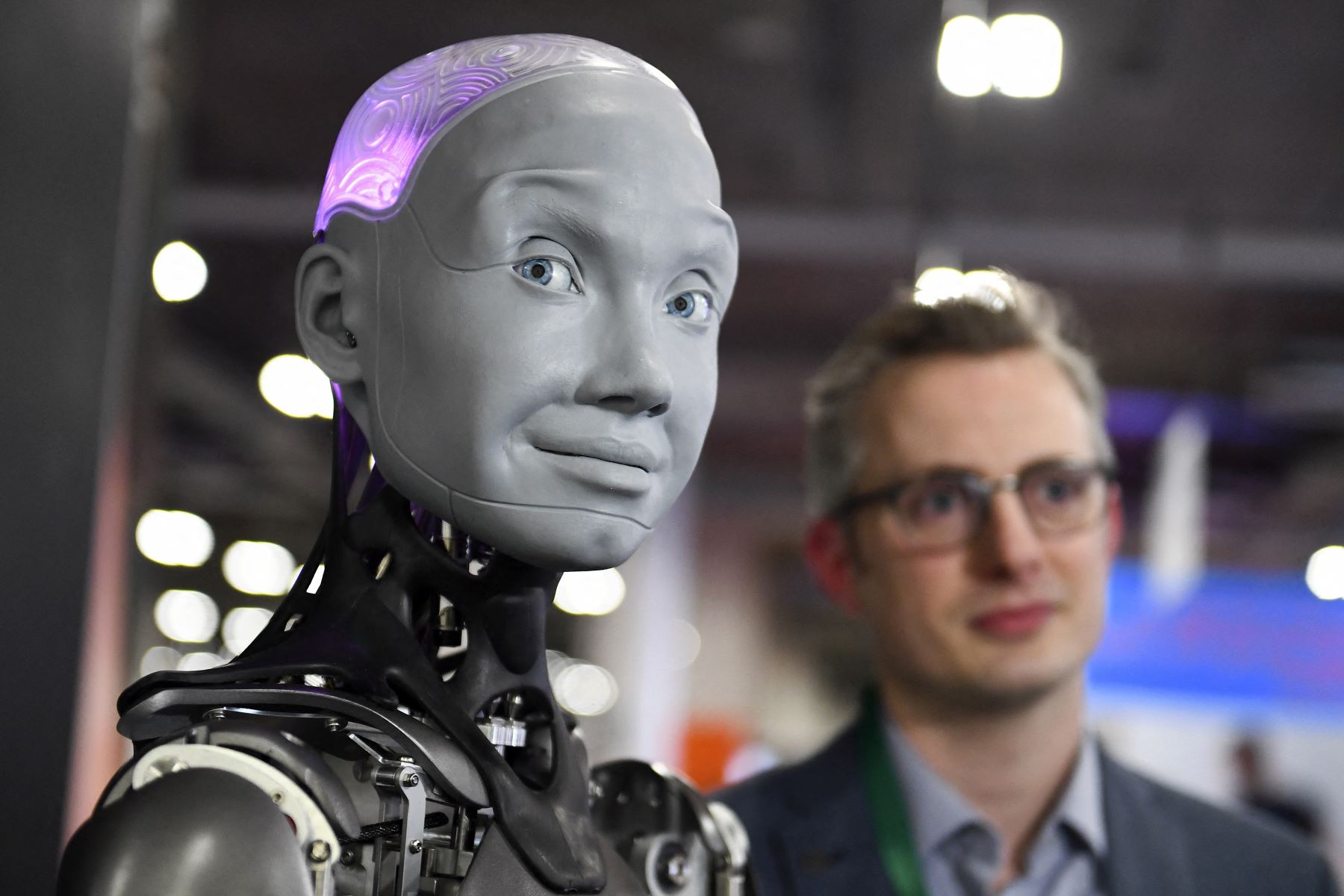 En esta fotografía referencial se aprecia a Morgan Roe, director de operaciones de Engineered Arts, quien habla sobre el robot humanoide Ameca con inteligencia artificial. Foto: AFP
