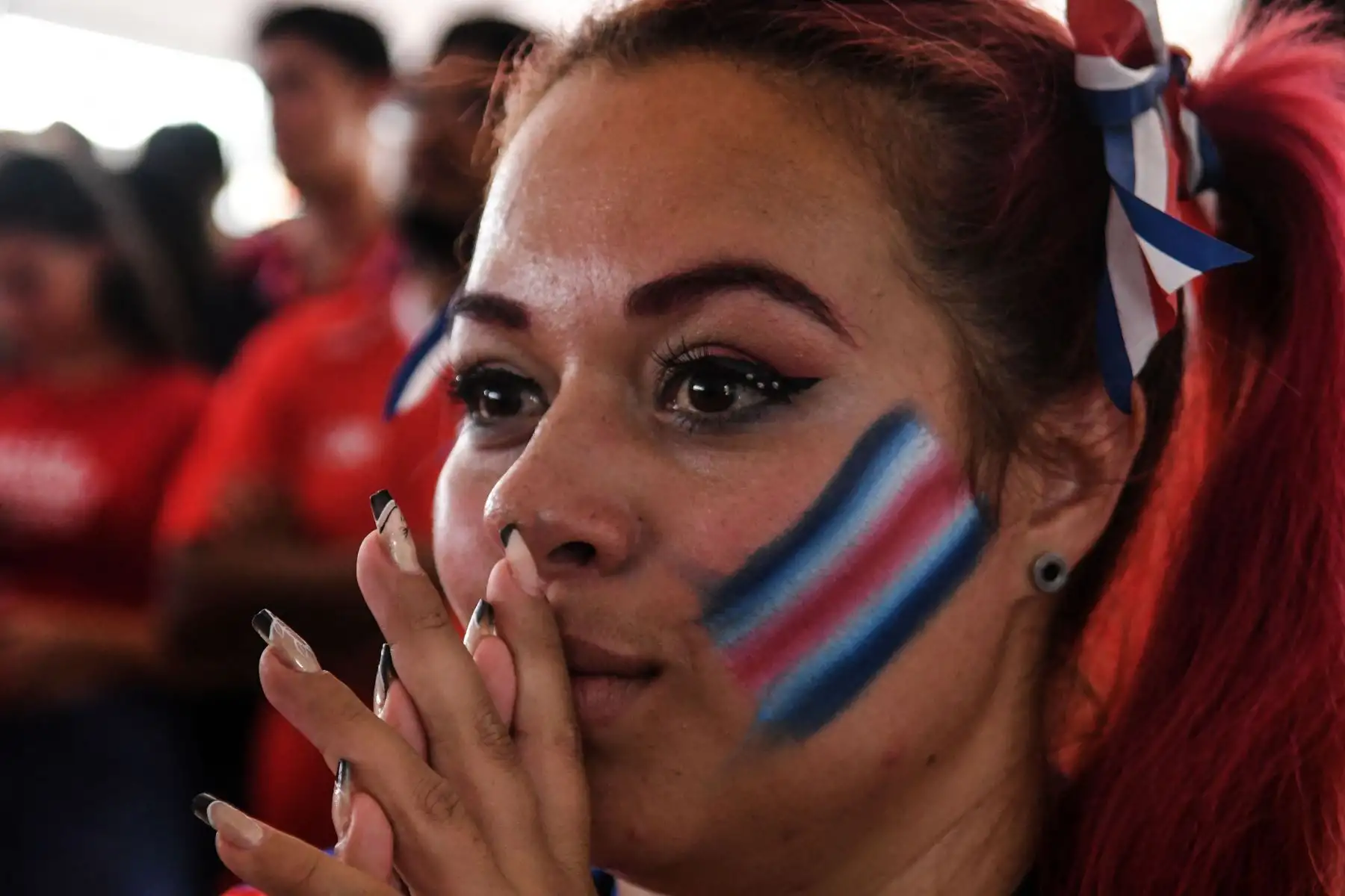 Una hincha  del fútbol costarricense reacciona mientras ve en una pantalla grande el partido de eliminatoria de clasificación para la Copa Mundial de la FIFA Qatar 2022 contra Nueva Zelanda celebrado en Doha.
Foto: AFP