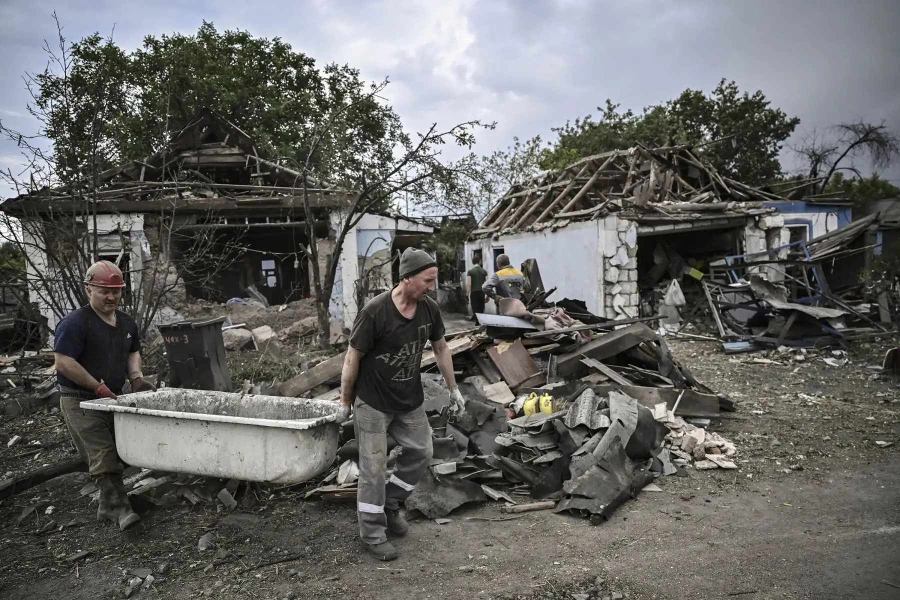 La gente limpia sus casas destruidas de los escombros en la ciudad de Dobropillia, en la región oriental de Ucrania de Donbas. Foto: AFP