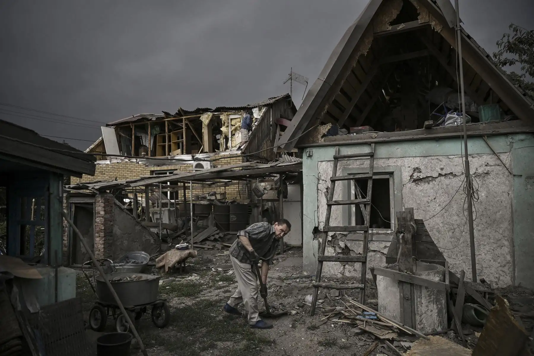 La gente limpia sus casas destruidas de los escombros en la ciudad de Dobropillia, en la región oriental de Ucrania de Donbas. Foto: AFP