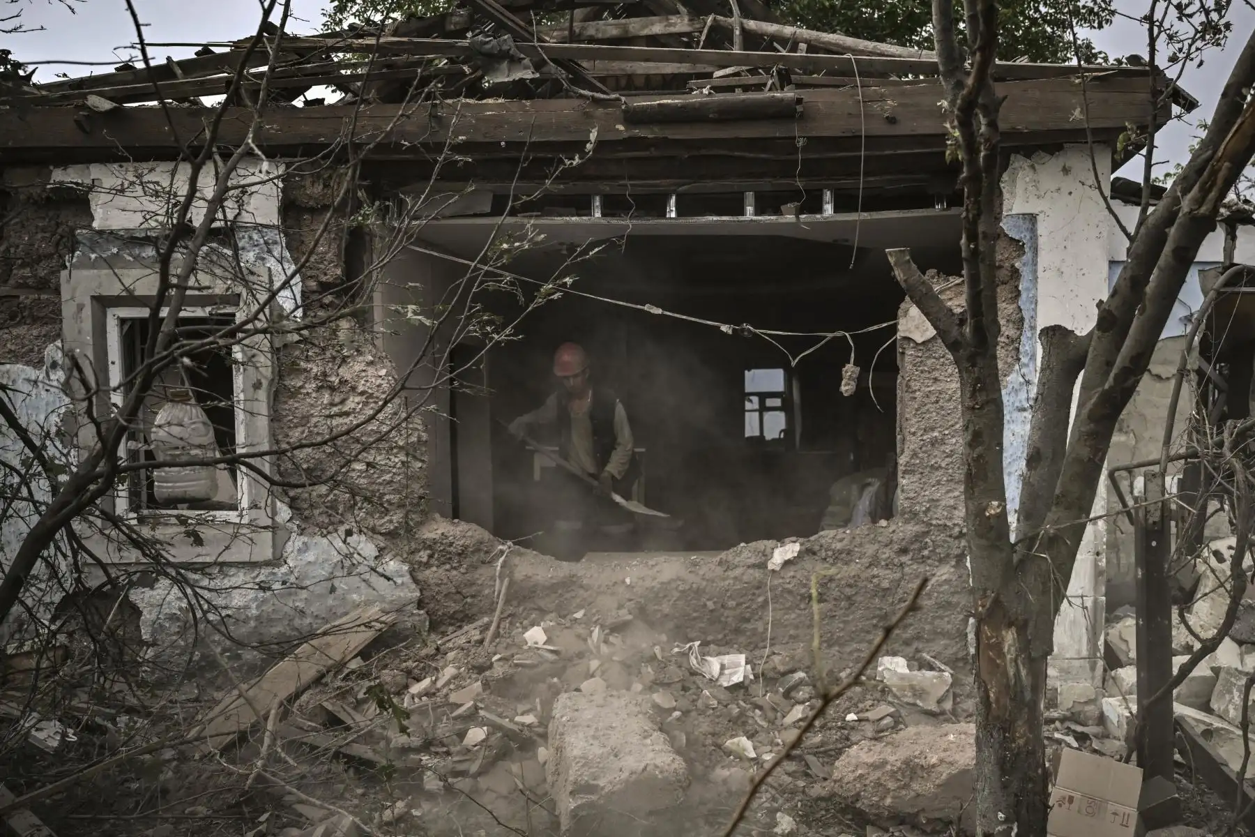 La gente limpia sus casas destruidas de los escombros en la ciudad de Dobropillia, en la región oriental de Ucrania de Donbas. Foto: AFP