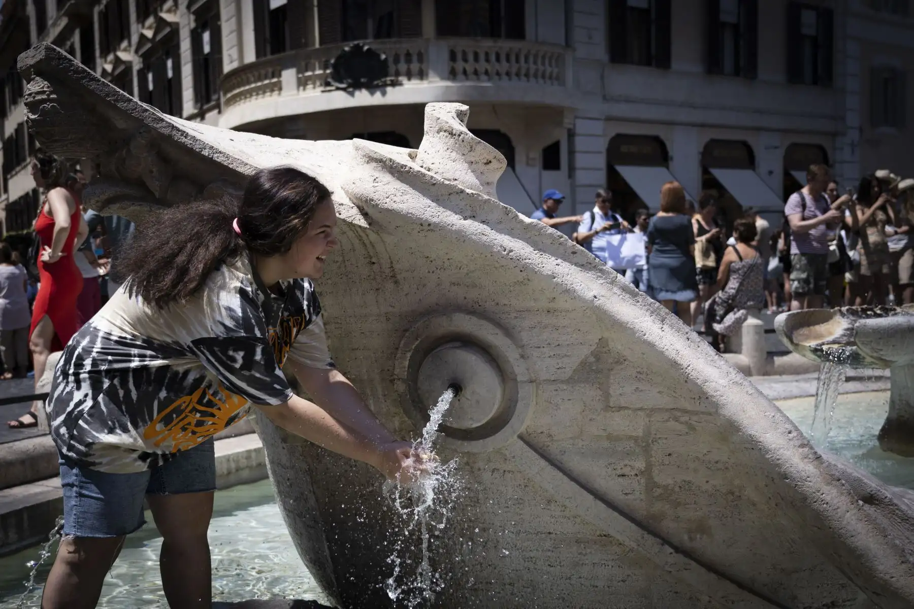 Un turista se refresca en la fuente Barcaccia junto a la Plaza de España en el centro de Roma.
Foto: AFP