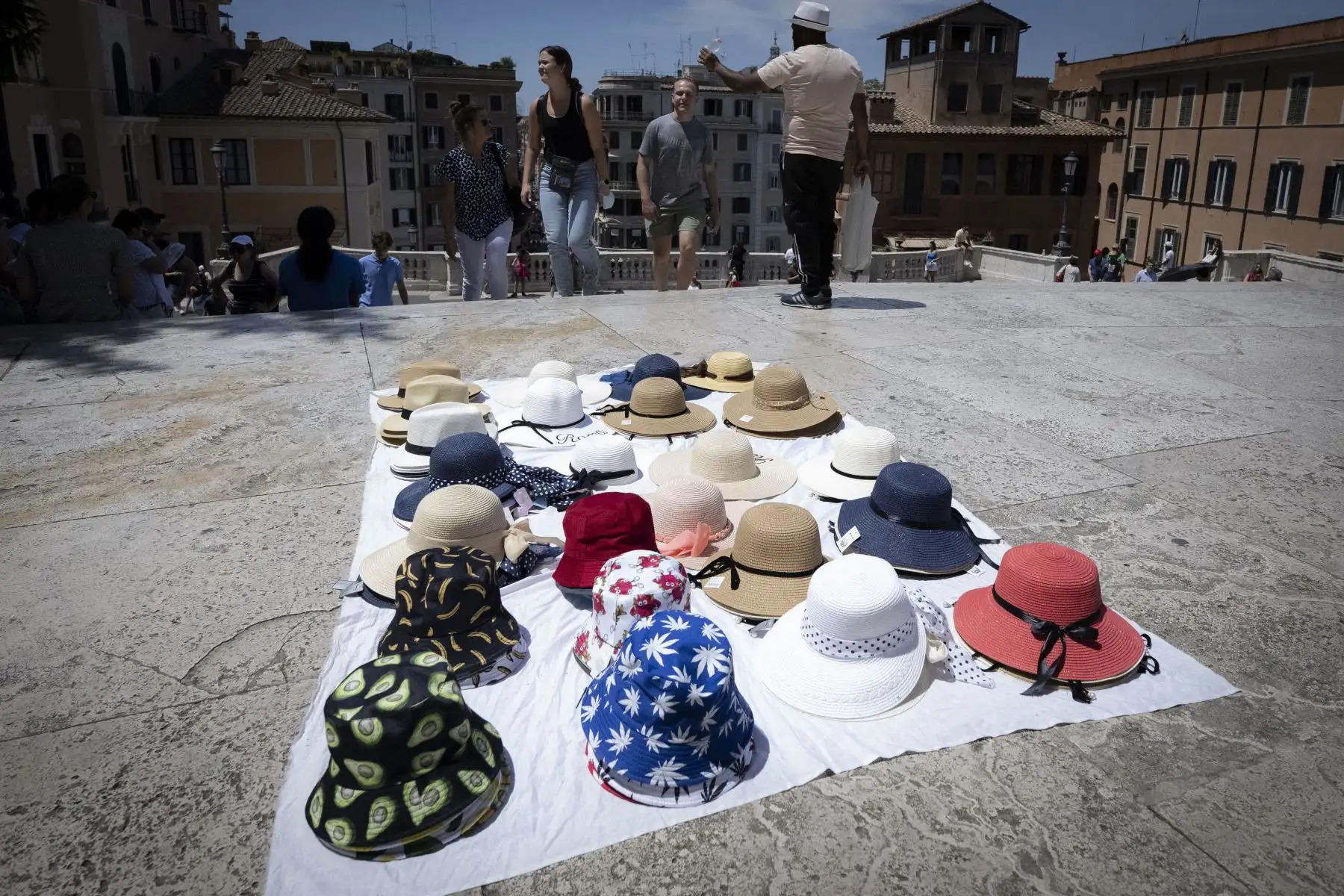 Un vendedor ambulante vende sombreros para el sol en la Plaza de España en el centro de Roma.
Foto: AFP