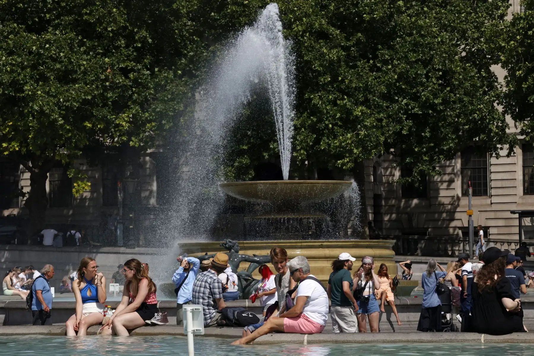 La gente se refresca junto a las fuentes de Trafalgar Square en el centro de Londres, en lo que se espera sea el día más caluroso del año hasta ahora en la capital. 
Foto: AFP