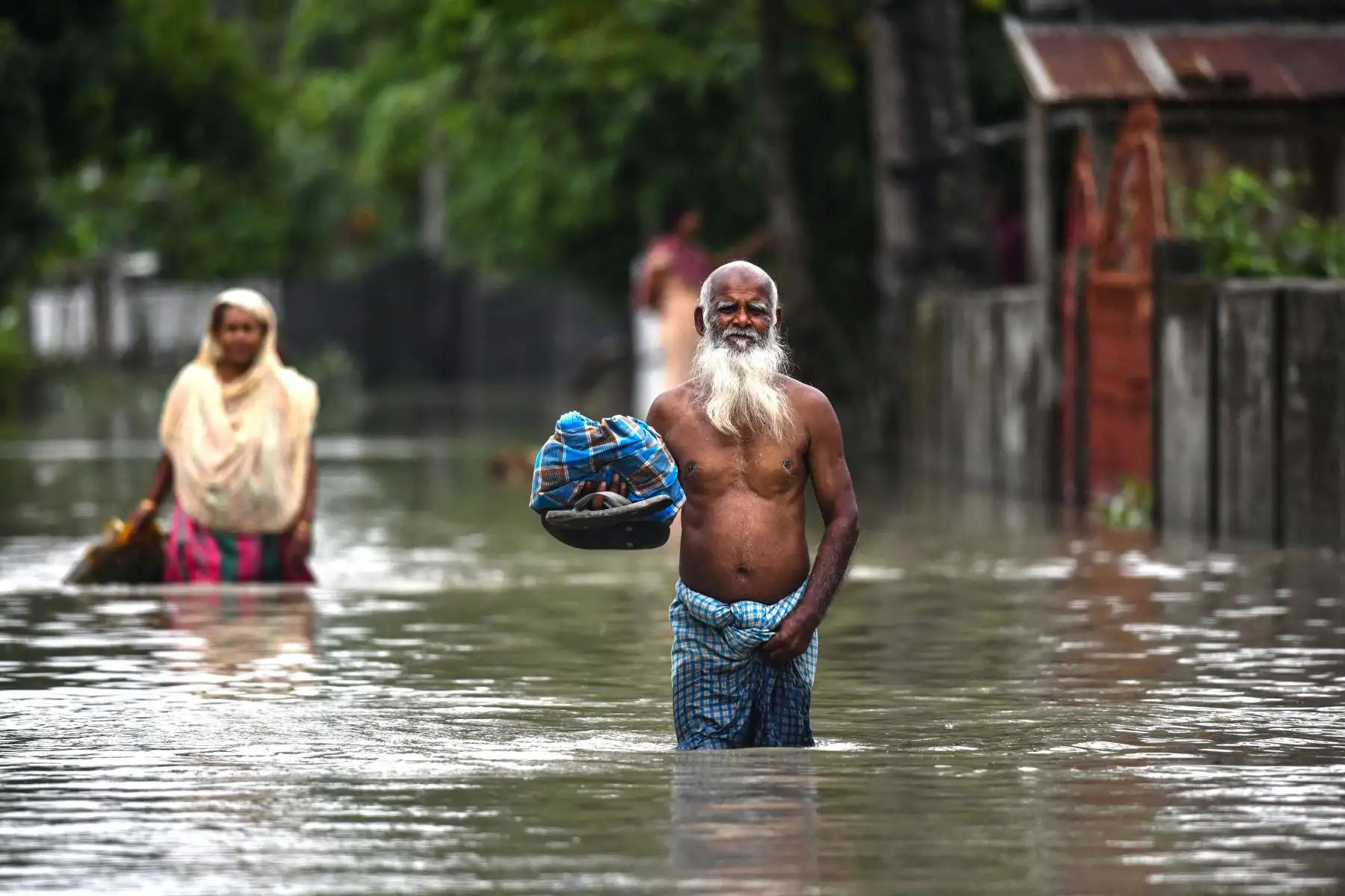 Un hombre vadea las aguas de la inundación en Rangia, en el distrito de Kamrup, en el estado indio de Assam.
Foto: AFP