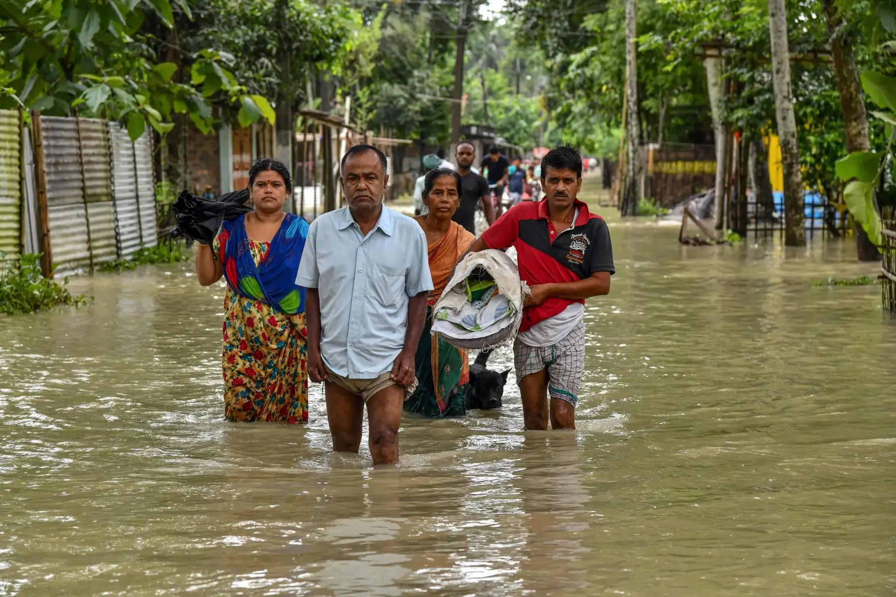 La gente vadea las aguas de la inundación en Solmara, en el distrito de Nalbari, en el estado indio de Assam.
Foto: AFP