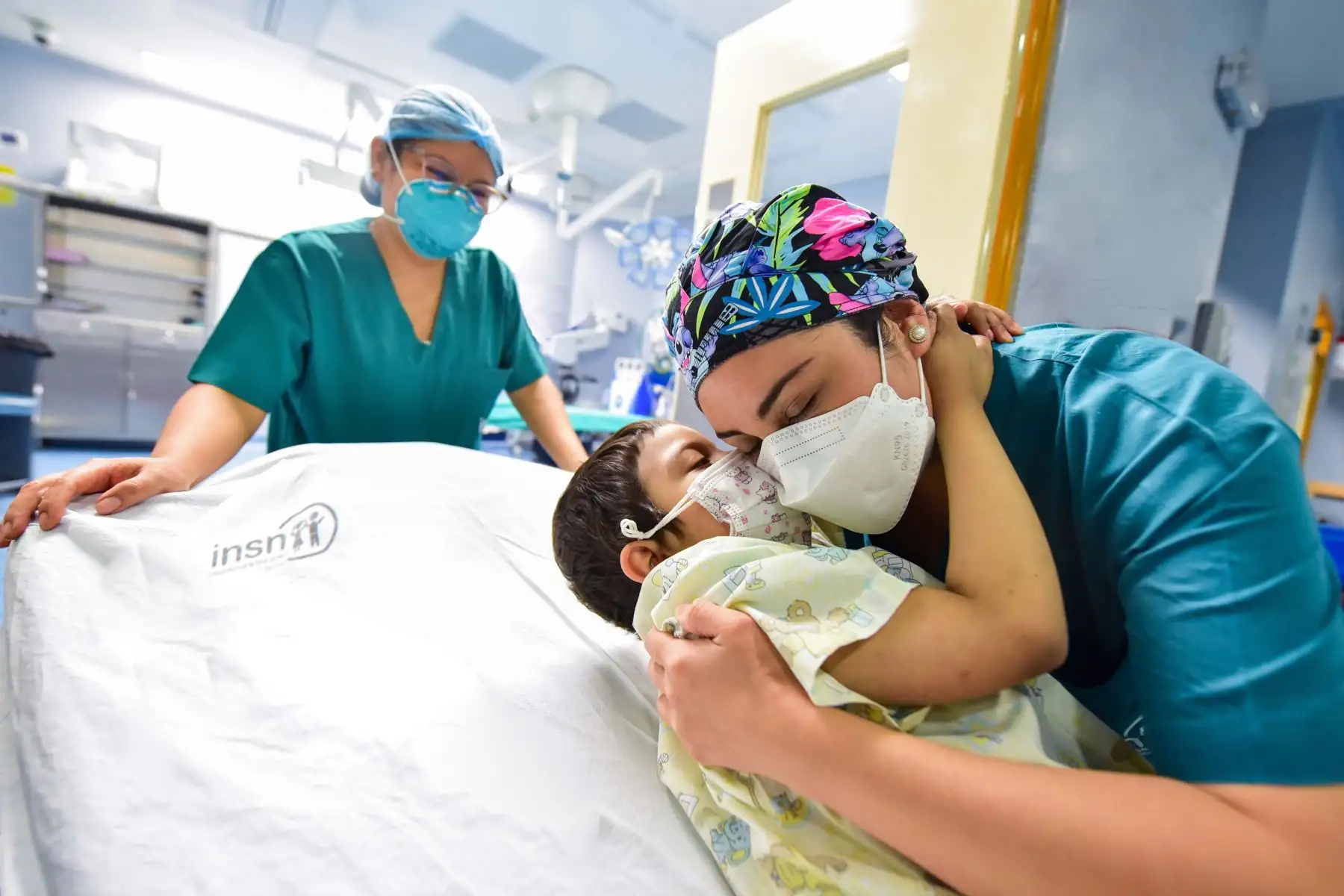 “Ingresando a Sala con un abrazo cálido”
El amor por los pacientes y el trato humanizado es algo que también se practica  en Sala de Operaciones. Así vemos a la pequeña Luna recibiendo el abrazo cálido de una de los médicos antes de iniciar un procedimiento quirúrgico como parte de su tratamiento hematológico. 
Foto: INSN de San Borja