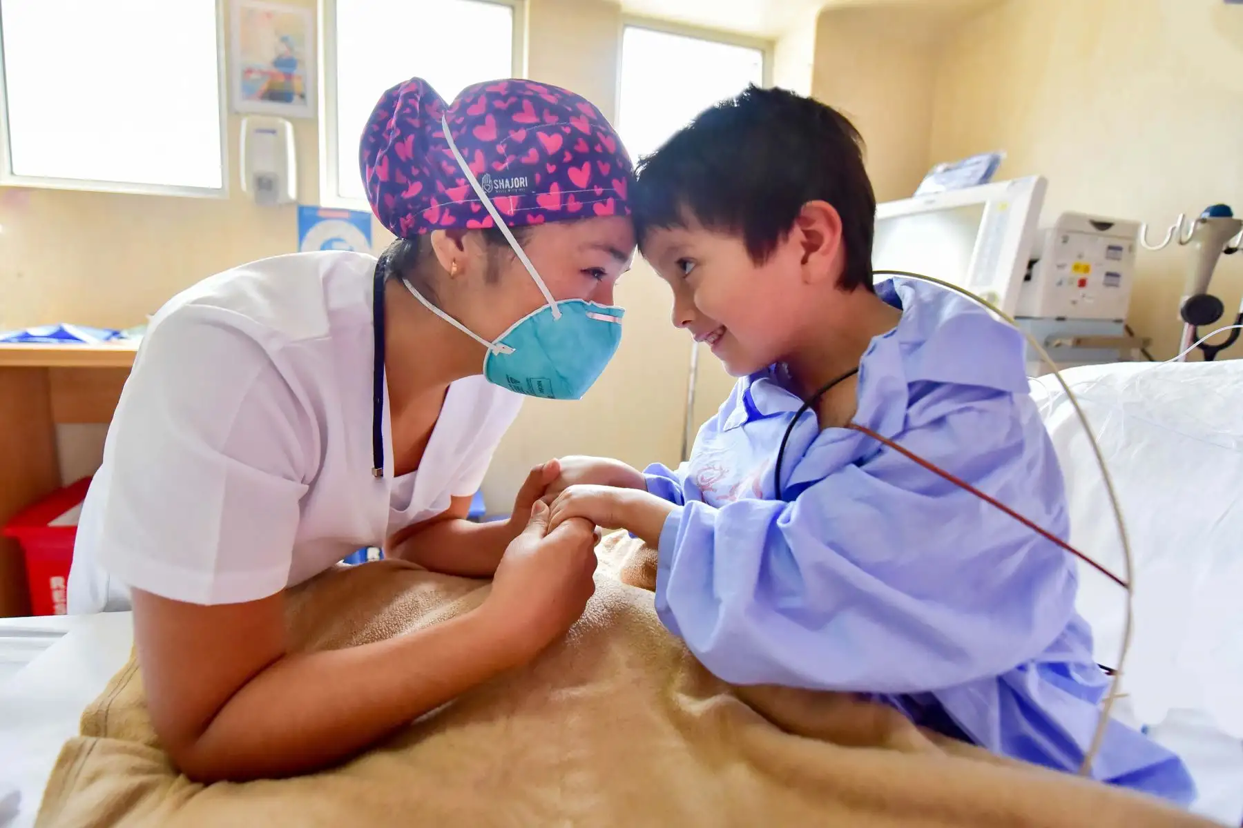 “Cuidando  con amor” En el INSN SB, las técnicas de enfermería son aquellas que están más cerca del paciente ya que están encargadas del cuidado personal  del paciente. Ellas están pendientes de las necesidades del paciente y al tratarse de niños, deben tener paciencia y empatía, como lo hace esta técnica ganándose el cariño de este pequeño post operado de una cardiopatía.
Foto: INSN de San Borja