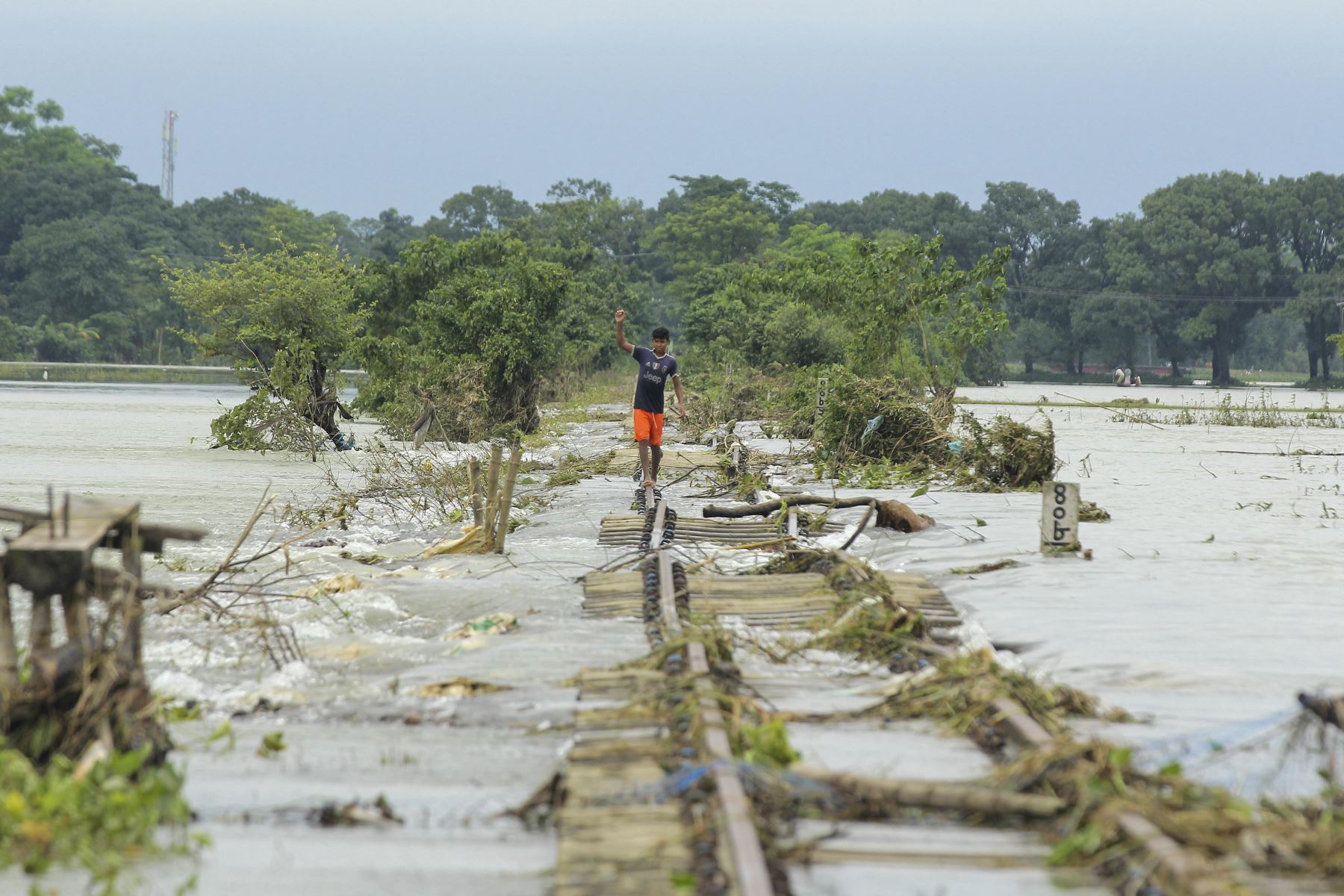 Un niño camina sobre una vía férrea dañada por inundaciones en Sunamganj. Foto: EFE
