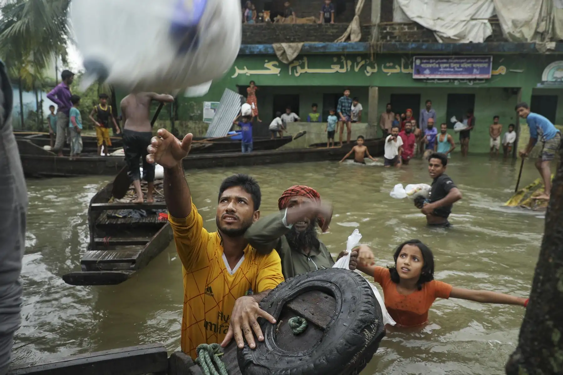 La gente se reúne para recoger ayuda alimentaria en una zona residencial inundada tras las fuertes lluvias monzónicas en Companiganj. Foto: AFP