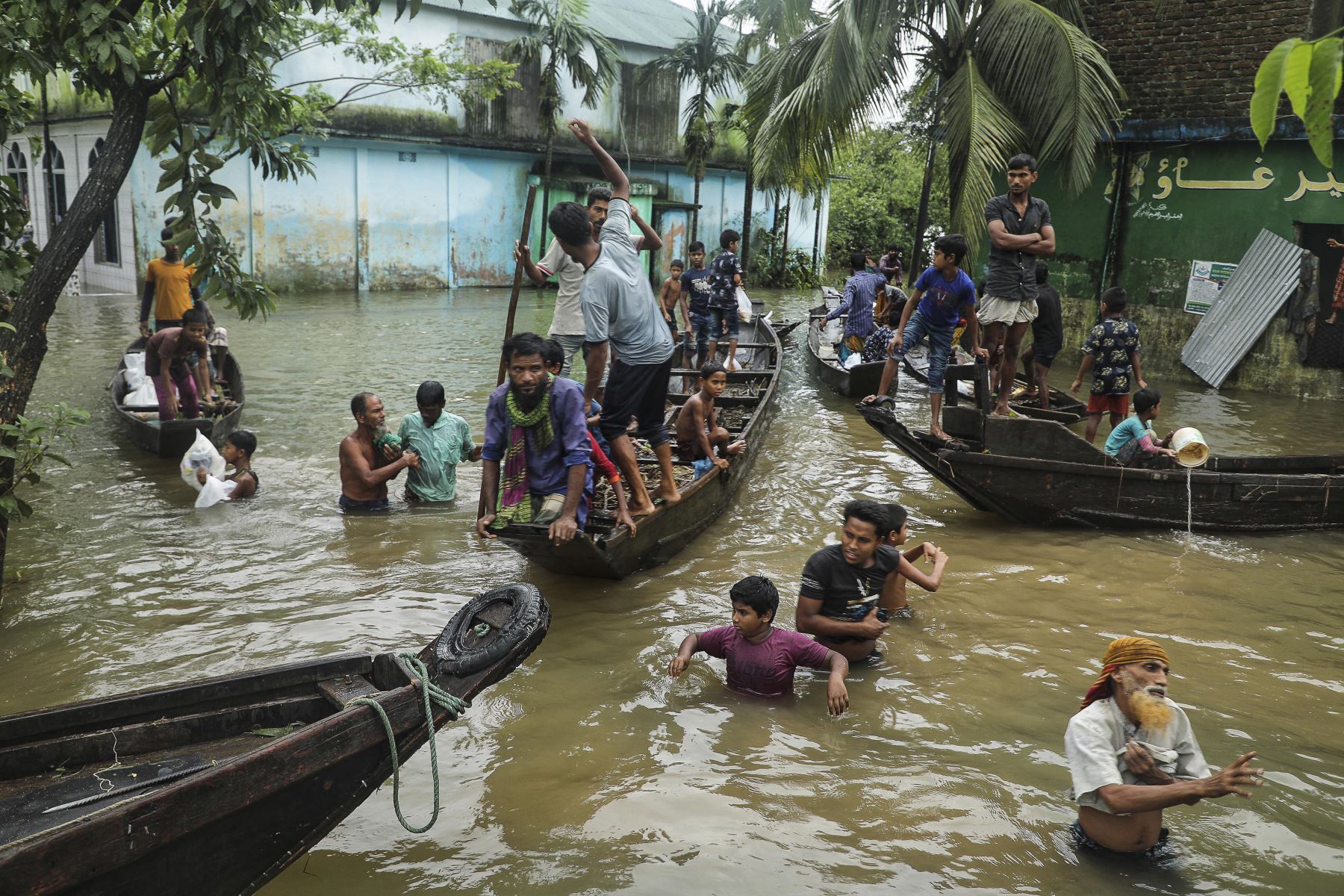 La gente se reúne para recoger ayuda alimentaria en una zona residencial inundada tras las fuertes lluvias monzónicas en Companiganj. Foto: AFP