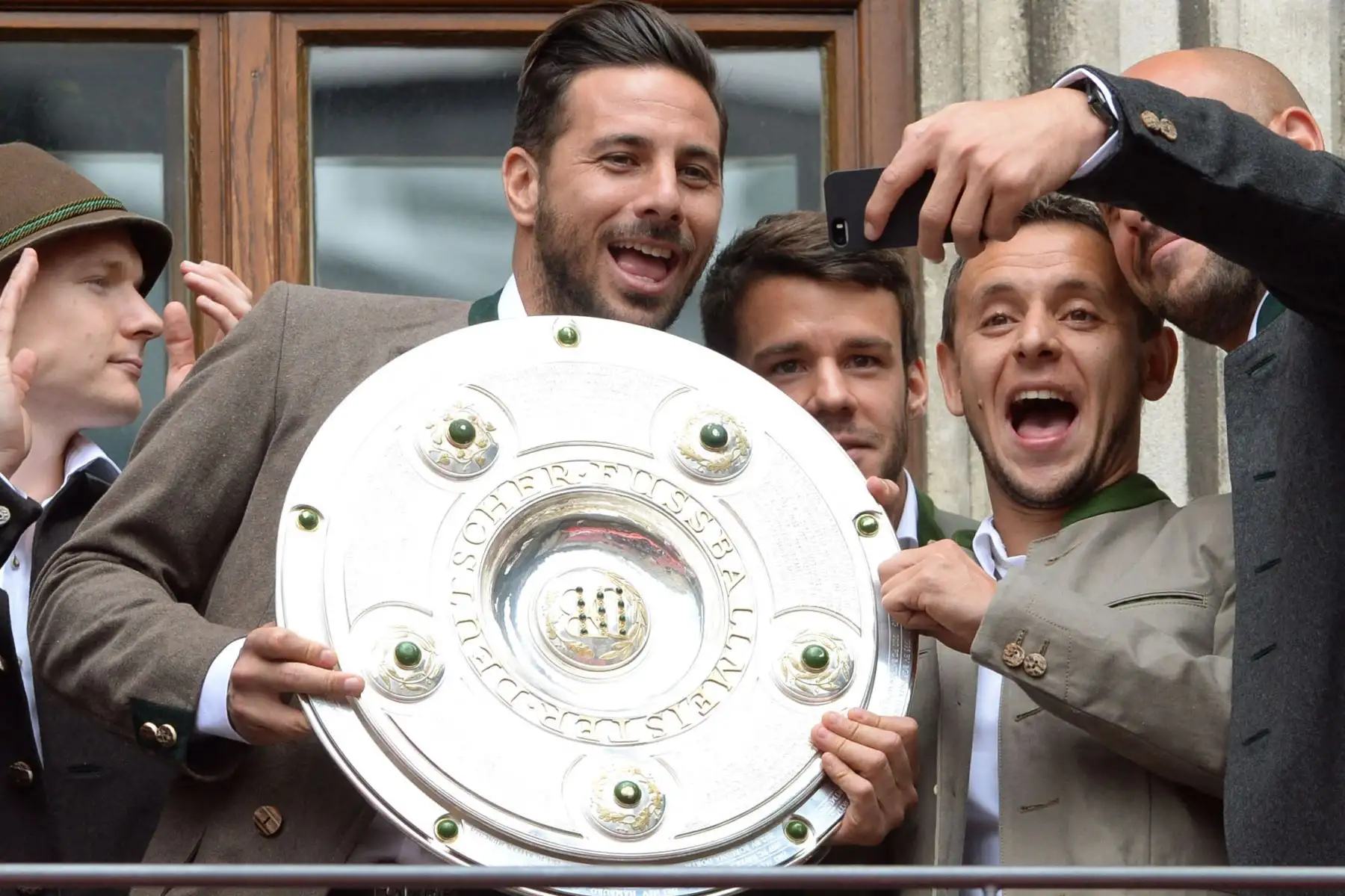 El mediocampista del Bayern Munich Sebastian Rode, el delantero peruano del Bayern Munich Claudio Pizarro, el mediocampista español del Bayern Munich Juan Bernat, el defensa brasileño del Bayern Munich Rafinha y el portero español del Bayern Munich José Manuel Reina se toman una selfie con el trofeo como club de fútbol FC de la Bundesliga. Foto: AFP